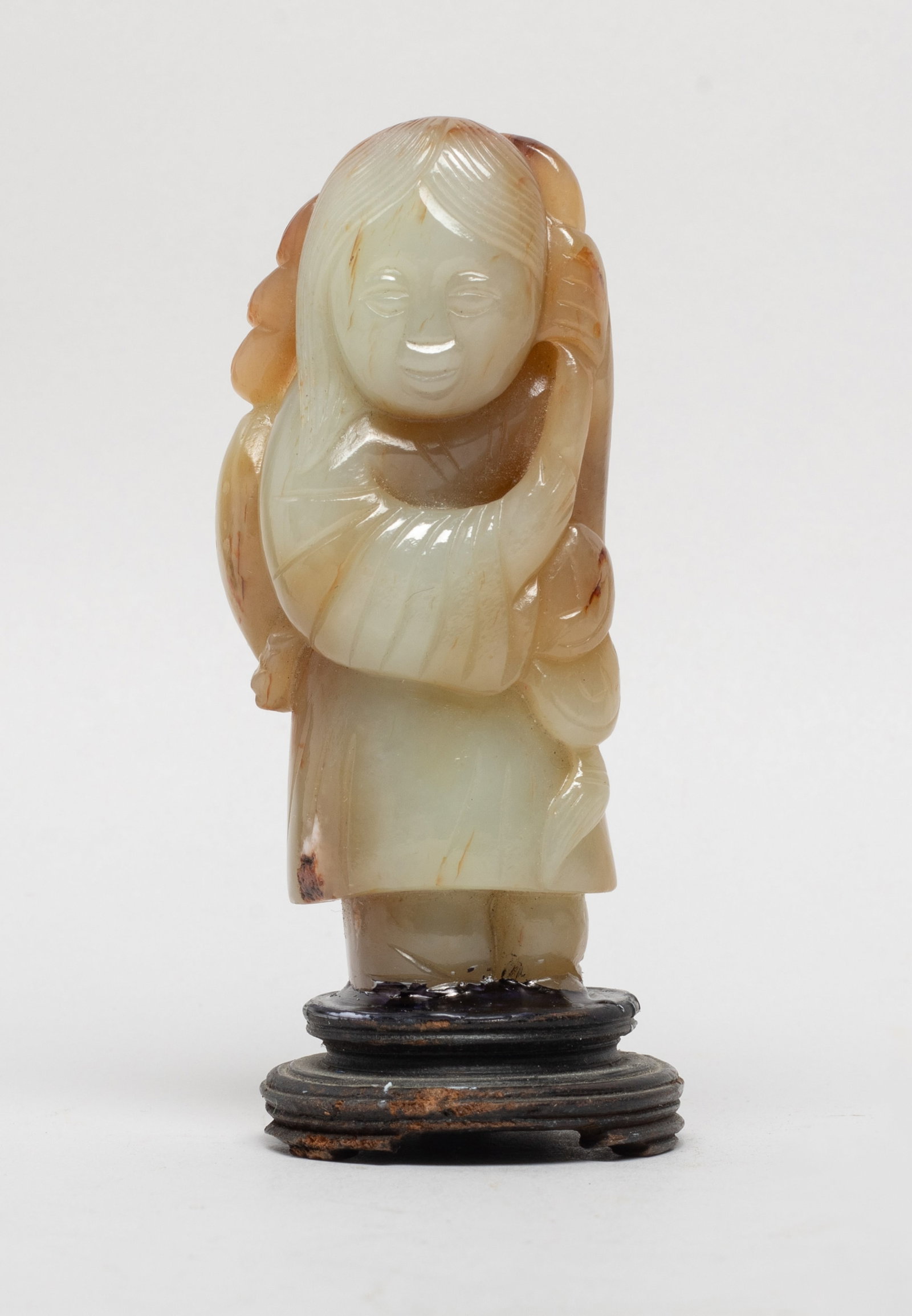 Estate Chinese Russet Jade w/ Wood Base: Carved as a standing figure grasping a string in hands, suspended with coins and a fish, affixed to a wood base. Approx. 3.7*1.55 inch (w/ base). The Estate of the Consignment Store Closed Sale. Palm