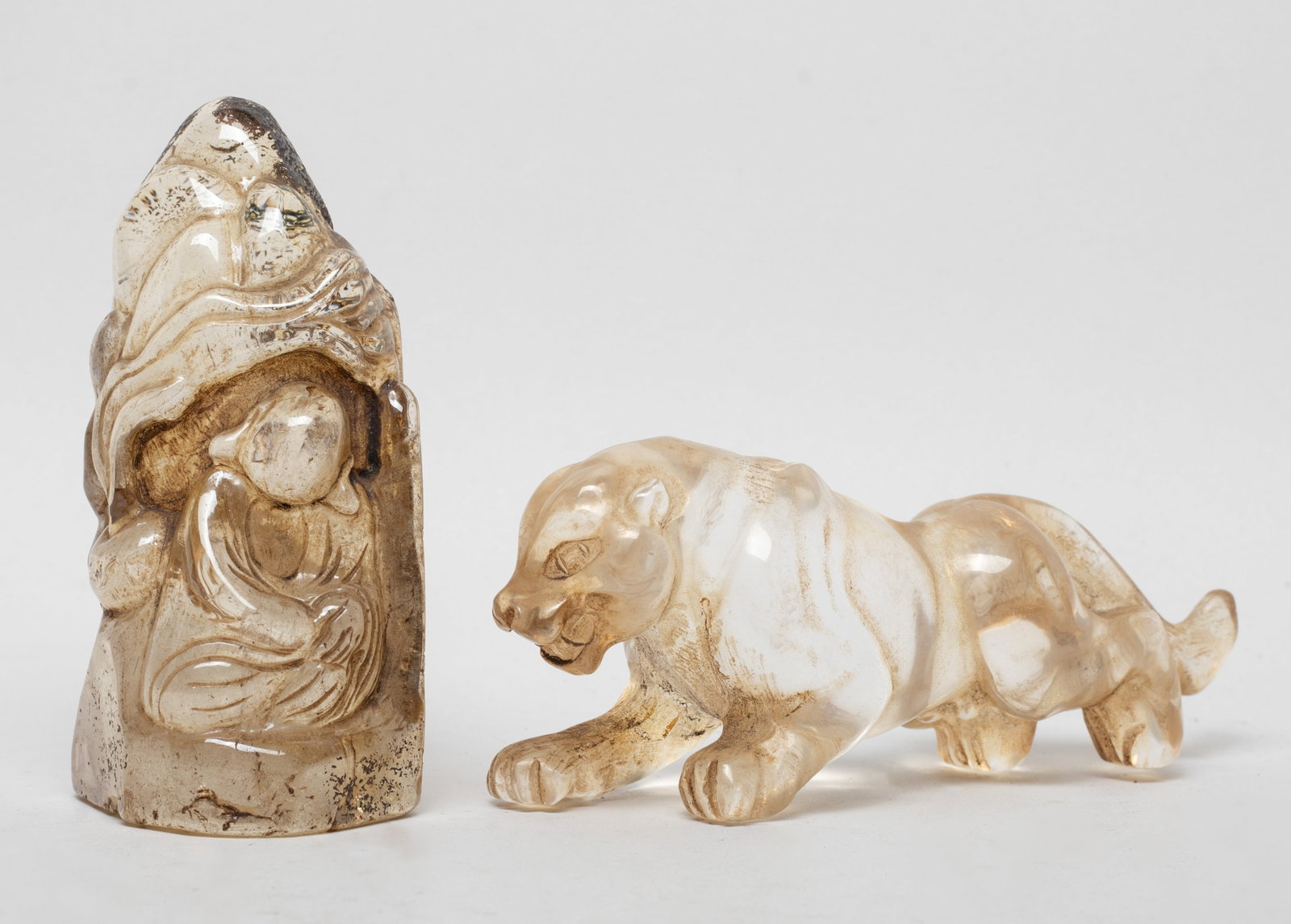 Two Chinese Rock Crystal Sculptures: One crystal sculpture carved as a panther, the tail is repaired, the other carved with a seated figure and a censer. Approx. 4.6*1.9*1.3 inch (larger).