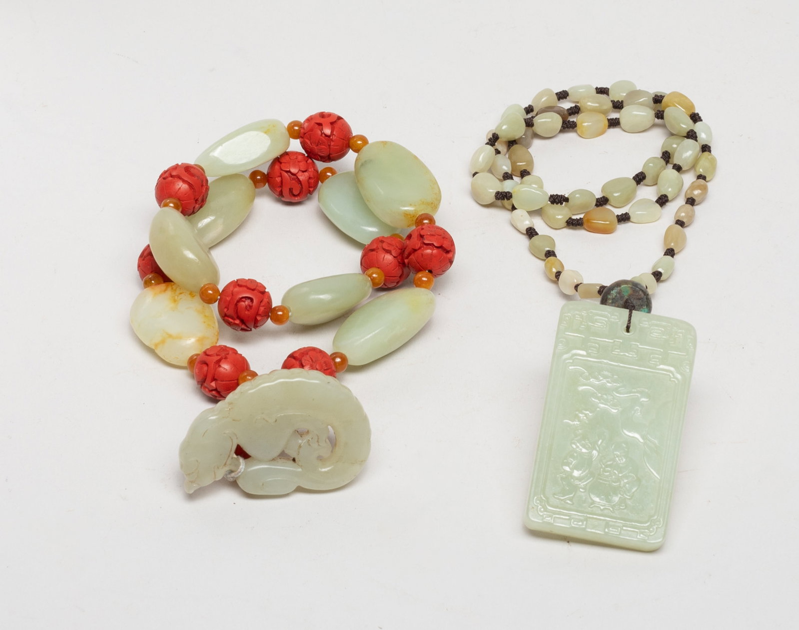 Two Chinese Export Jade, Cinnabar Necklaces: One russet jade bead necklace with a jade plaque, one side carved with two boys under a bat and a pine tree, the reverse inscribed with related poems, the other jade pebble bead and cinnabar bead