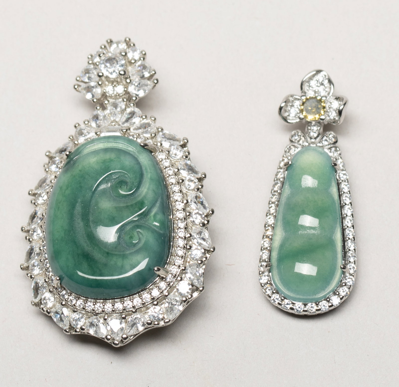 Chinese Jade Jadeite Pendants: Two Chinese jade jadeite pendants, one carved of lingzhi form, the other of pea pod form. Approx. 1.53*0.9 inch (larger).