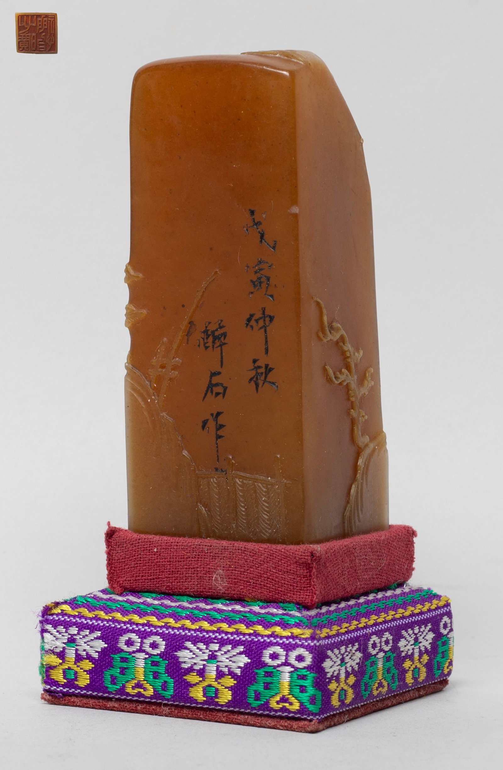 Chinese Russet Skin Shoushan Stone Seal: Of square section, the exterior carved with two figures in landscape setting, with stand. Approx. 3.17*1.22*1.22 inch (w/o stand).
