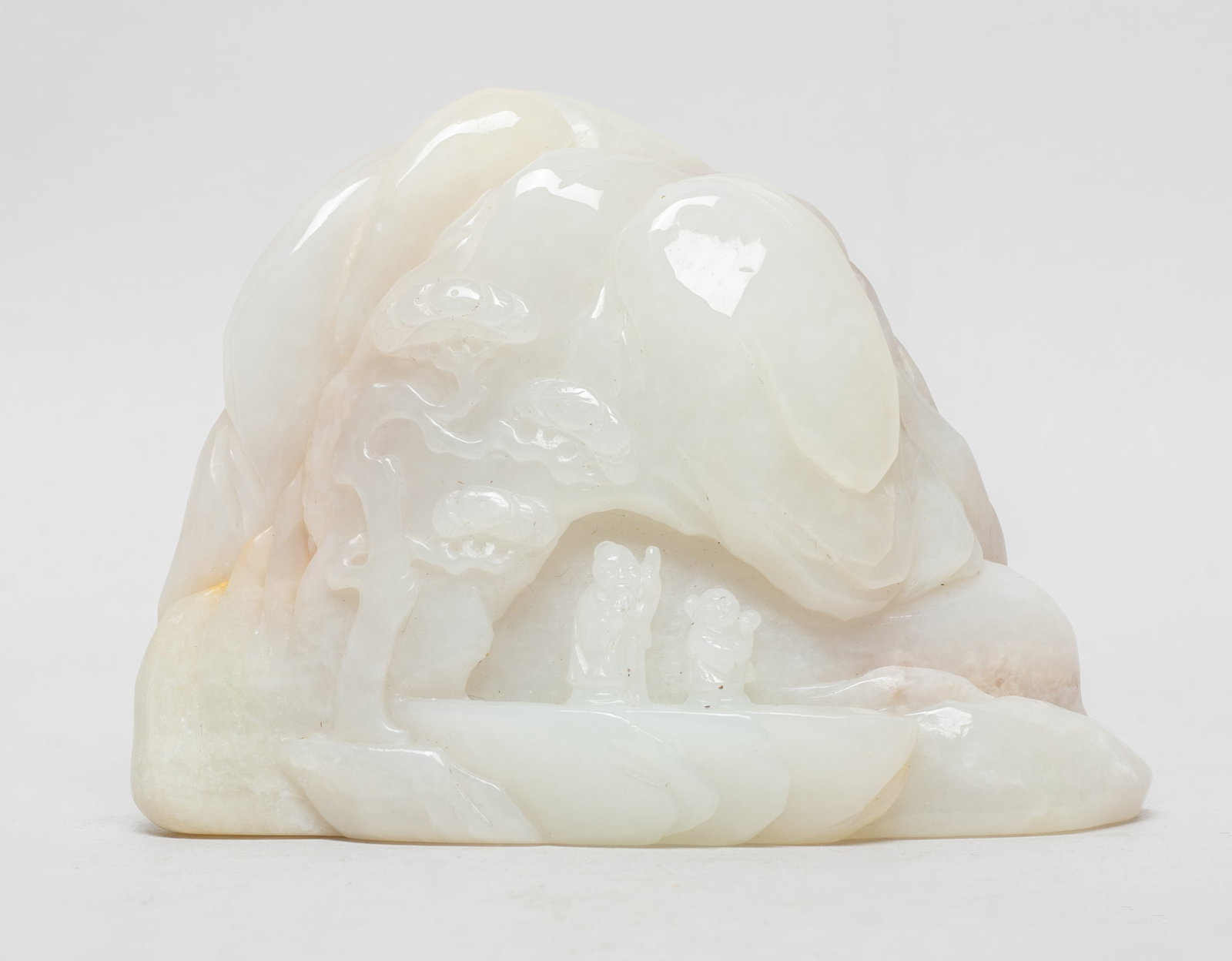 Chinese Russet Jade Table Sculpture: Worked in varying levels of relief to depict craggy mountains, carved with a sage and his attendant under a tall pine tree, the reverse with a deer looking backward, the stone of a white tone with