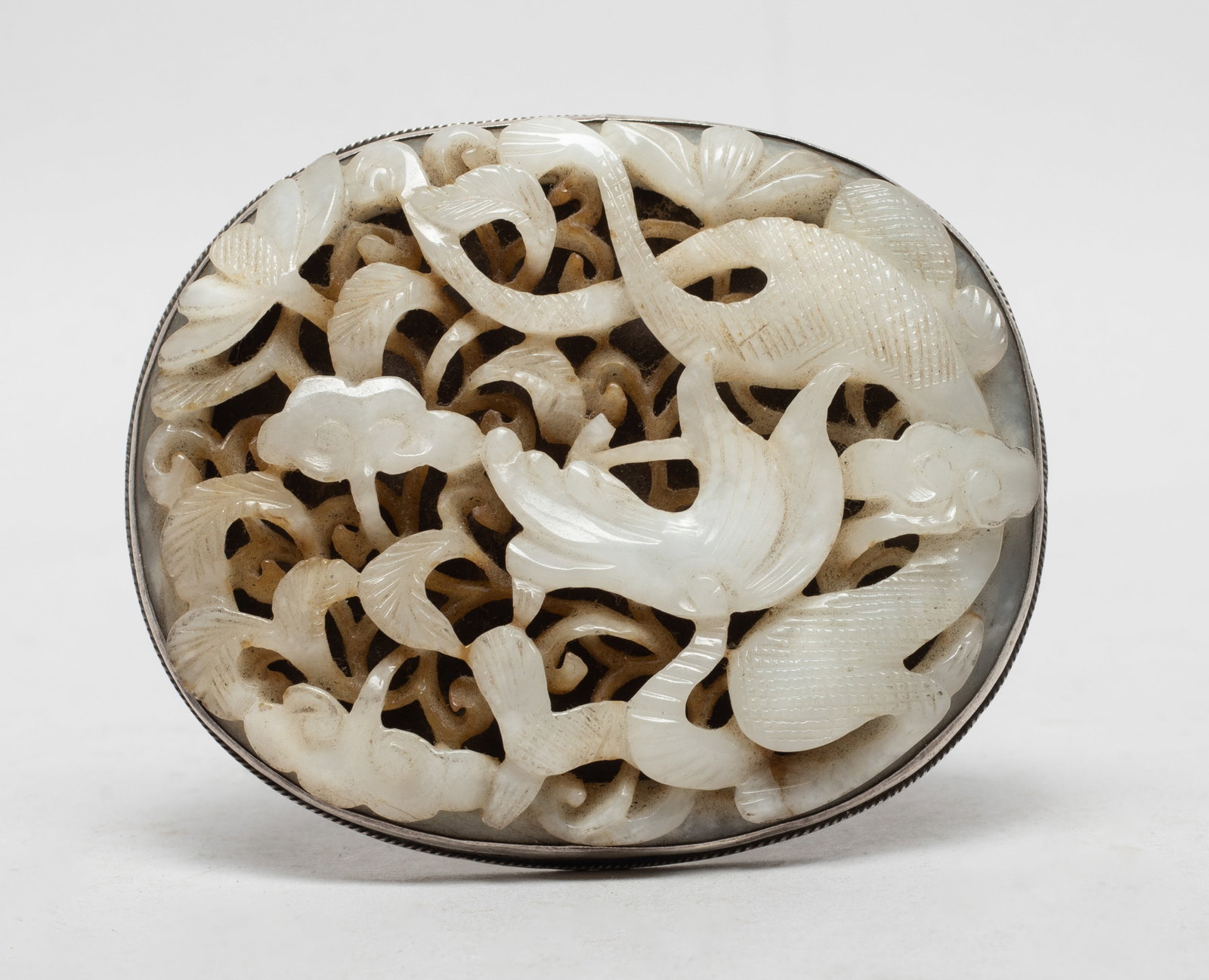 Chinese Jade / Stone & Silver Belt Buckle: Of oval shape, carved in openwork with a dragon sinuous amidst leafy lingzhi foliage, the underside with two two-character mark. Approx. 3.55*2.95 inch.
