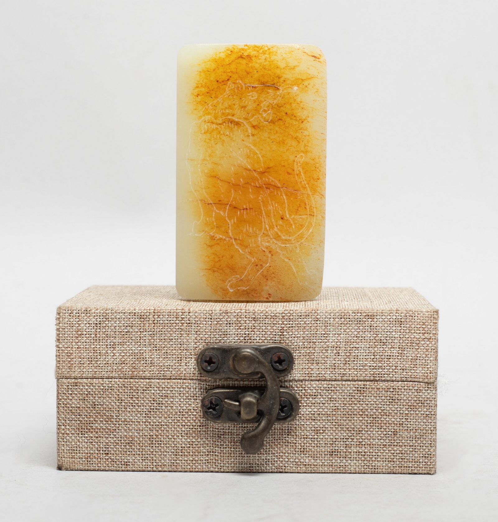Collectible Chinese Russet Jade Belt Buckle: The russet jade belt buckle incised with a beast on the top, the underside inscribed with four characters, with box. Approx. 2.45*1.43*0.6 inch (w/o box).