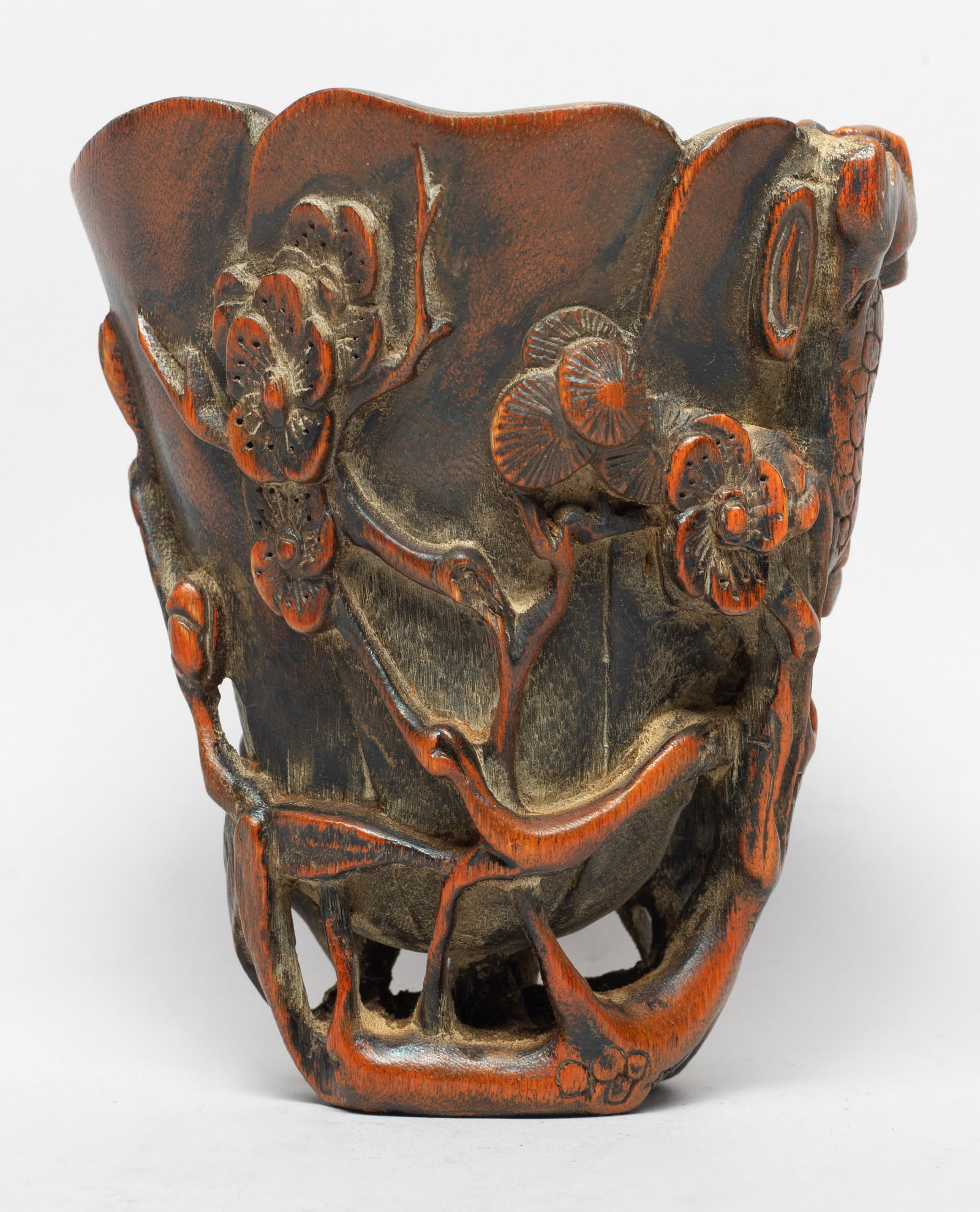 Collectible Chinese Wood Carved Liberation Cup: Shaped as a mallow flower with overlapping petals rising from a reticulated base in the form of a twig intertwined with flowering plum branches, pine branches and bamboo that rise up the exterior