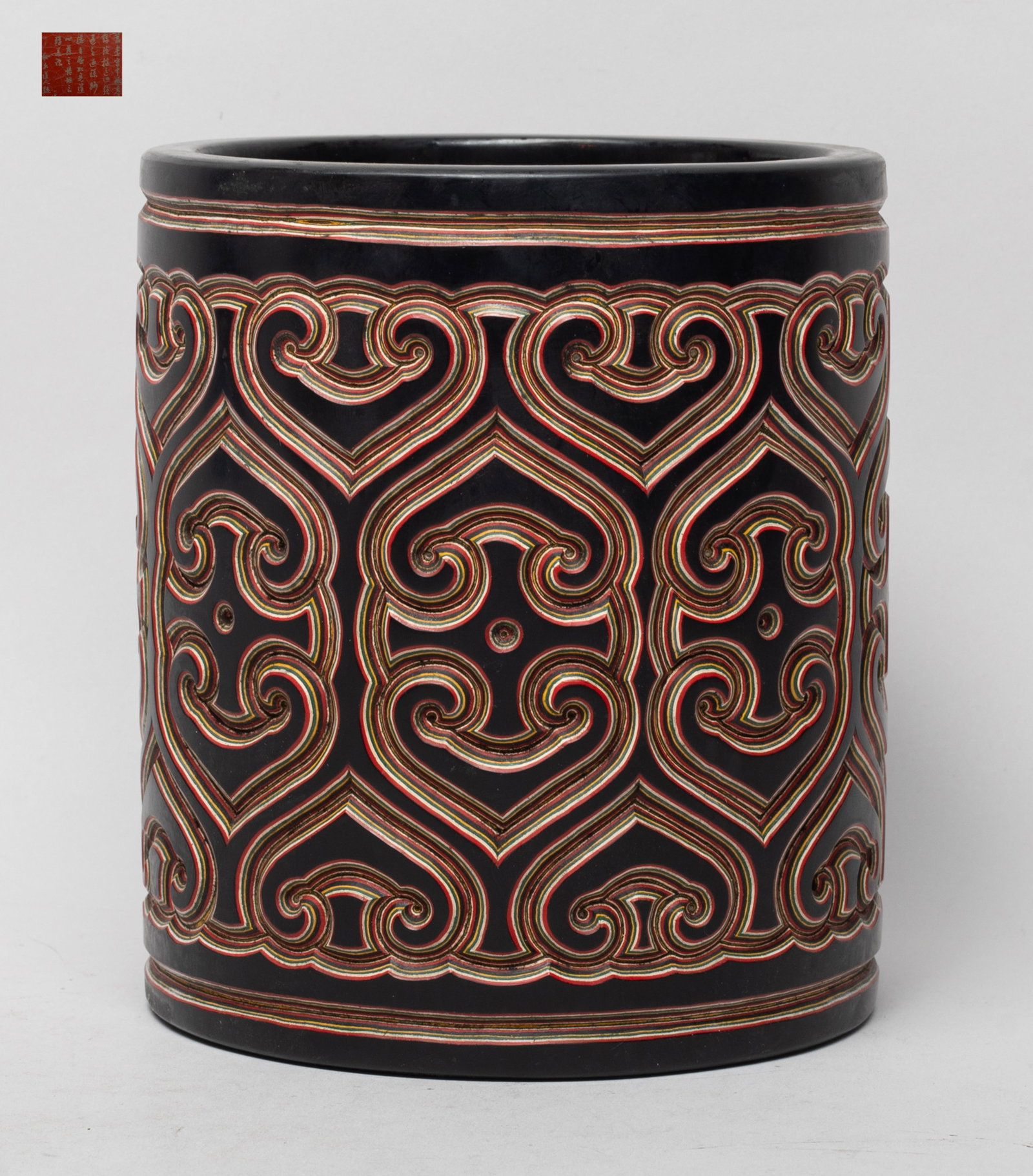 Chinese Lacquer Carved Brush Pot: Of cylindrical form, the exterior carved with continuous stylized ruyi head patterns, the bottom with inscription. Approx. 5.8*5.1 inch.