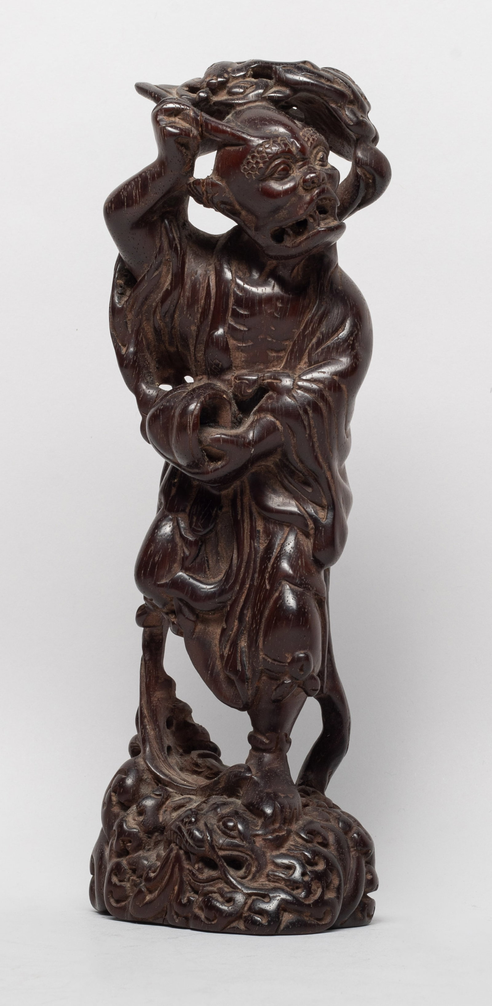 Heavy Chinese Wood Carved Sculpture of Kui: The figure carved with left leg stepping on a beast among waves, right leg lifting back, his left hand holding a bowl and right hand grasping a pen, bats hovering over his head. Approx. 9.2*3.2*2.4 in