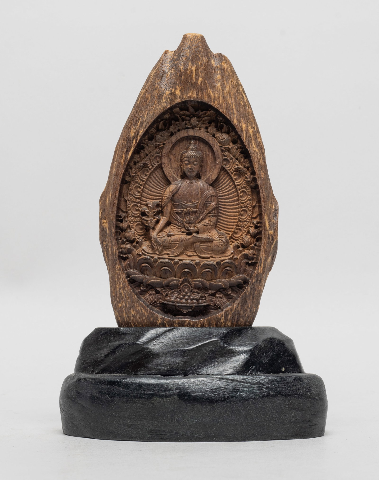 Chinese Agarwood Sculpture: Carved with Buddha seated on a lotus throne, the hands holding flower, the statue surrounded by flowers, with stand. Approx. 90 gram, 6*2.8*0.7 inch (w/o stand).