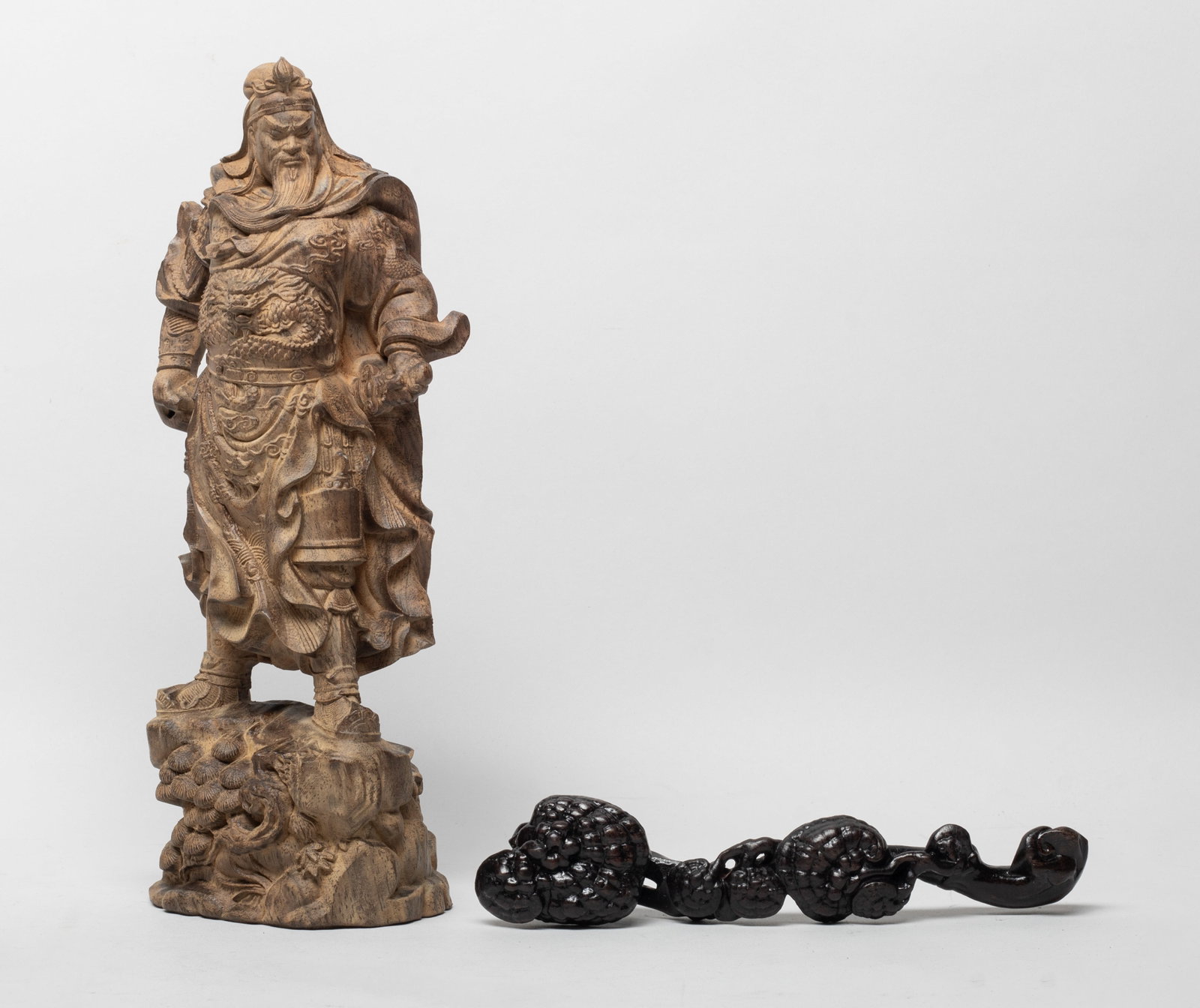 Tall Chinese Wood Sculpture of Kuanti & Ruyi: One carved as Kuanti standing on rock issuing pine branches, the general wearing armour and cape and holding a sword in hands, the other reticulated as lingzhi fungus growing from a common stem. Appro