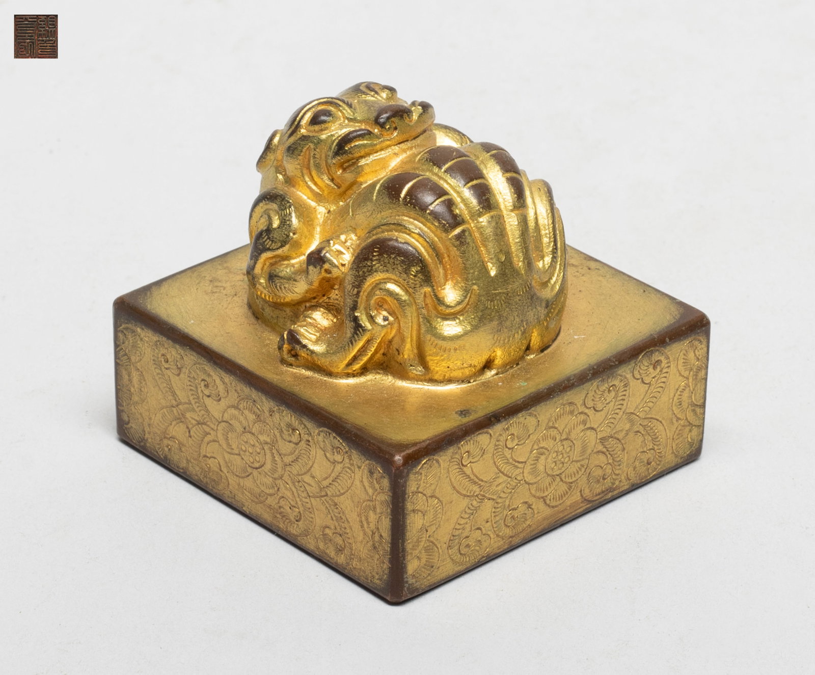 Estate Chinese Gilt Bronze Seal: Of square section, the top cast with a raised mythical beast, the sides incised with flowers. Approx. 2.25*2.25*2 inch.