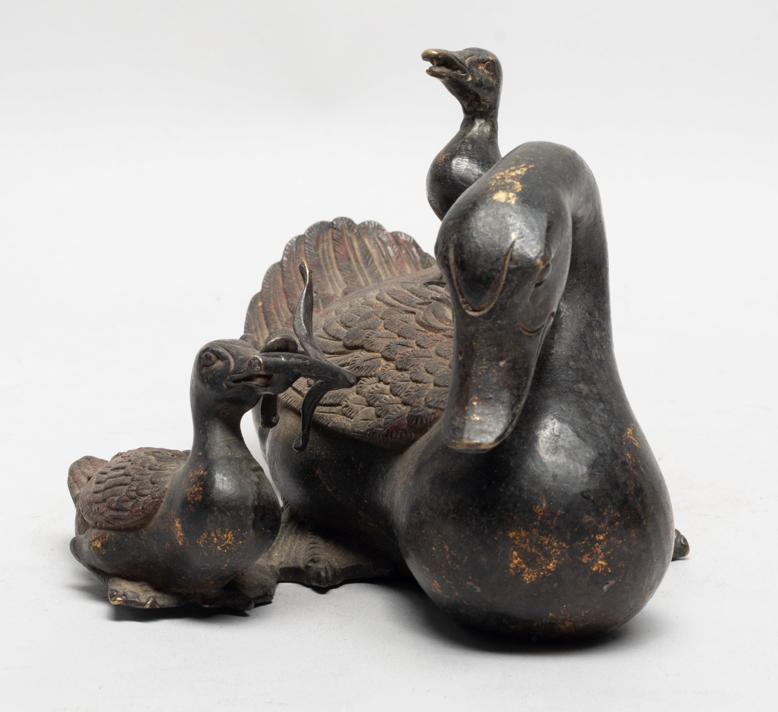 Rare Chinese Painted Bronze Sculpture: Cast as a recumbent duck with its head turned slightly to the right, a young bird on its back and another young bird on its right grasping a twig in mouth. Approx. 7.2*5.2*4.2 inch.