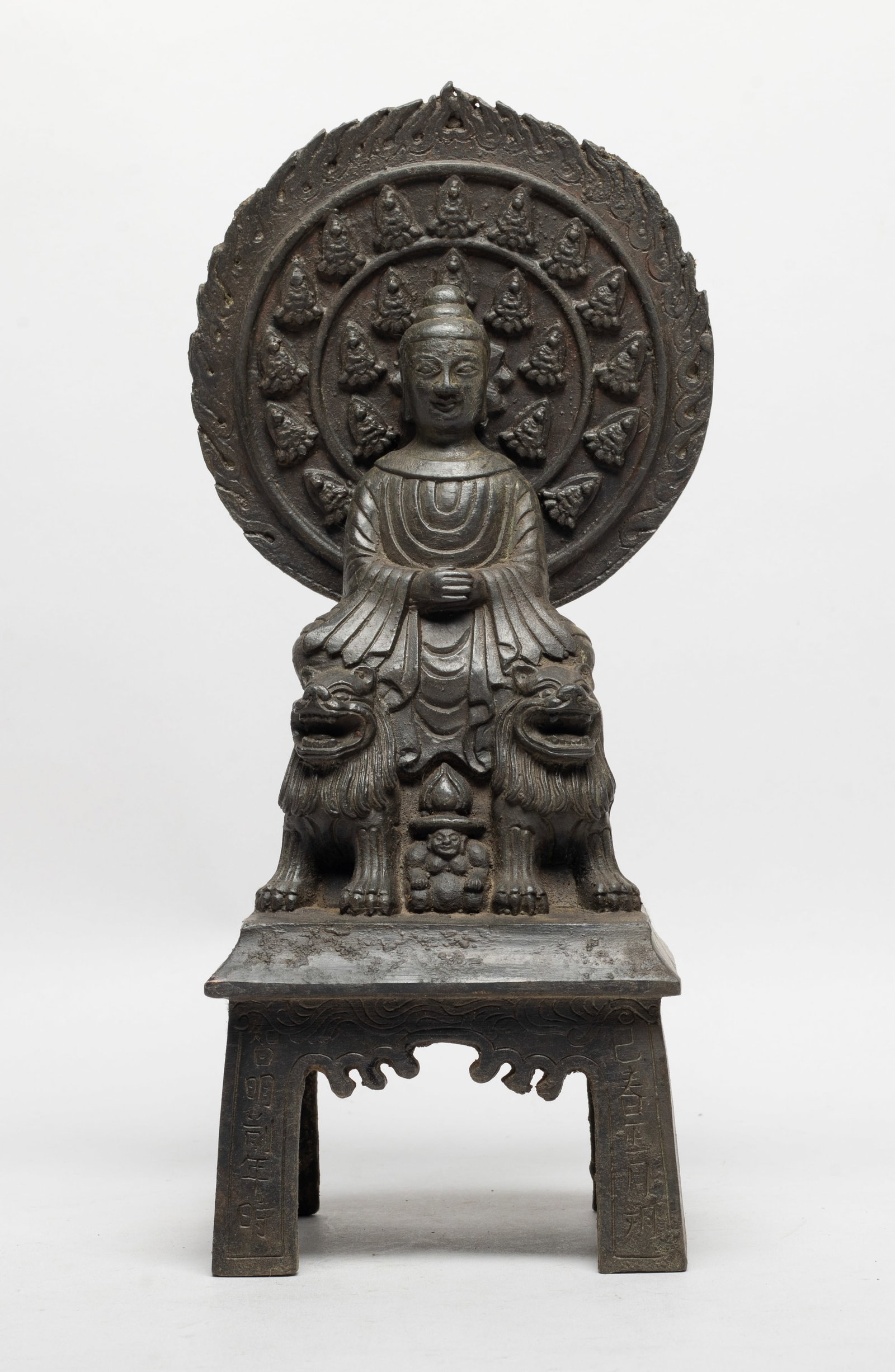 Tall Chinese Bronze Sculpture of Buddha: The Buddha cast seated on a pair of beasts on a tall pedestal, the hands covering his belly, behind his head with a circular mandorla cast with borders of seated Buddha. Approx. 11.3*5.1*3.7 inch.