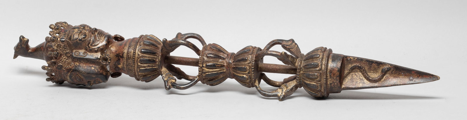 Chinese Sino-Tibetan Bronze Vajra: Cast with a horse head on the top, below with three masks and lotus, ending with a triple-sided blade carved with snake on each side. Approx. 17*2.5 inch.