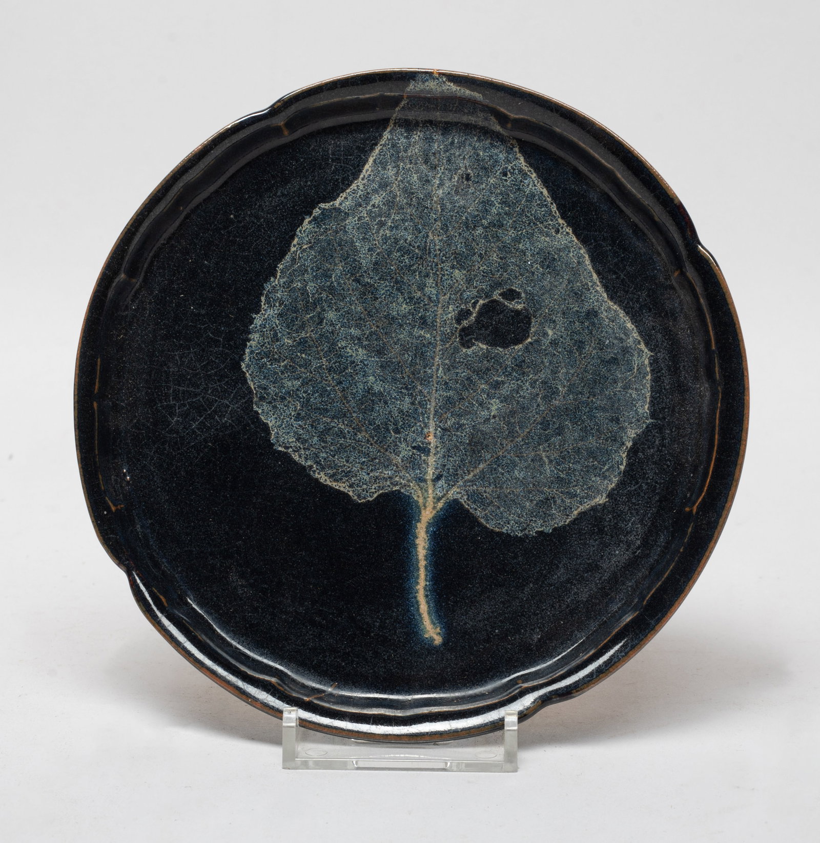 Chinese Jizhou Type Porcelain Dish: The plate interior decorated with a imprint of a leaf revealing its veins against black glazed background, the bottom unglazed. Approx. 5.8 inch D.
