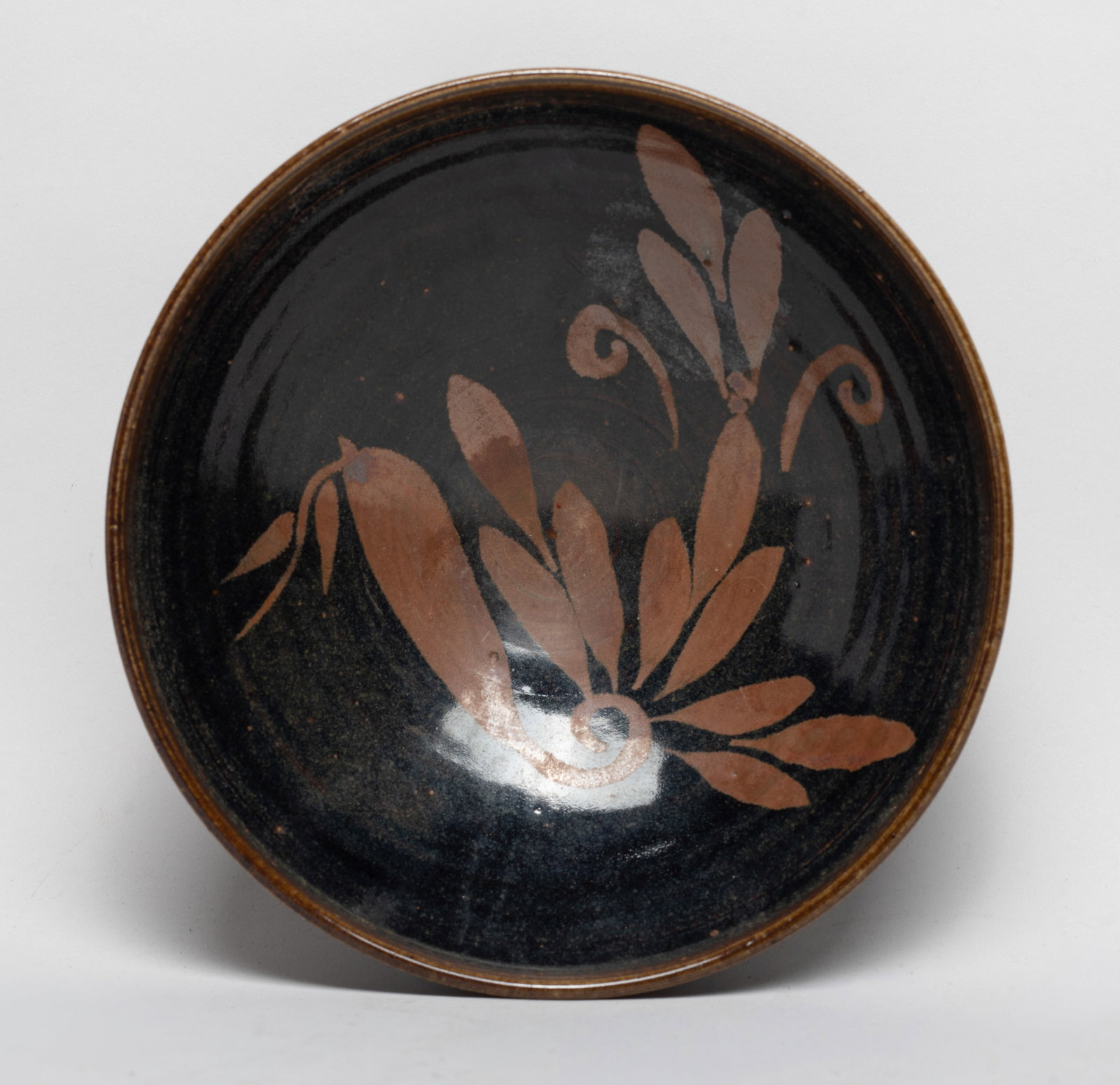 Large Chinese Export Porcelain Bowl: The bowl interior decorated with russet-color flowers on black glazed background, the glaze stopping above the unglazed foot. Approx. 7*2.6 inch.