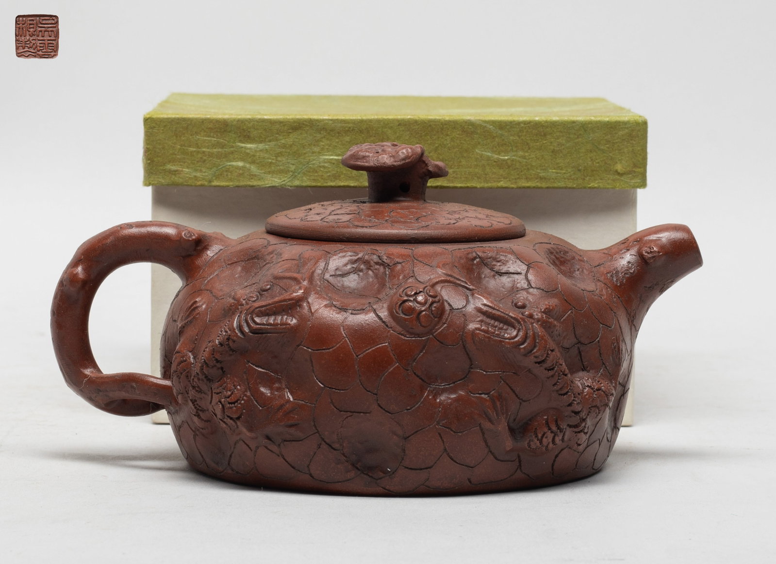 Chinese Export Yixing Zisha Tea Pot: The tea pot body carved of gnarled trunk form, carved with dragons in pursuit of ball, the lid with a lingzhi finial, the lid interior and the pot bottom with seal mark, with box. Approx. 6.5*4.7*3.2