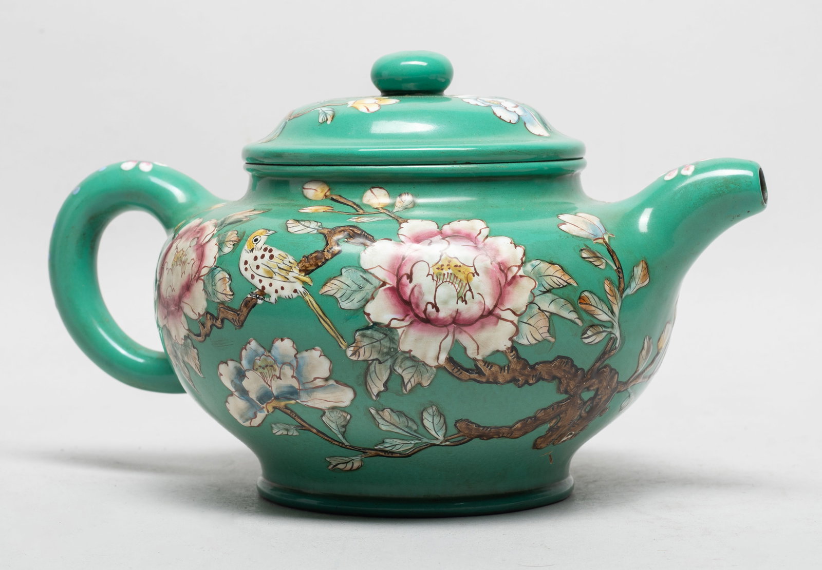 Large Chinese Enameled on Zisha Tea Pot: The tea pot and lid exterior enameled and painted with a bird on blossoming peony branches against turquoise-green glazed body. Approx. 9*6*5.1 inch.