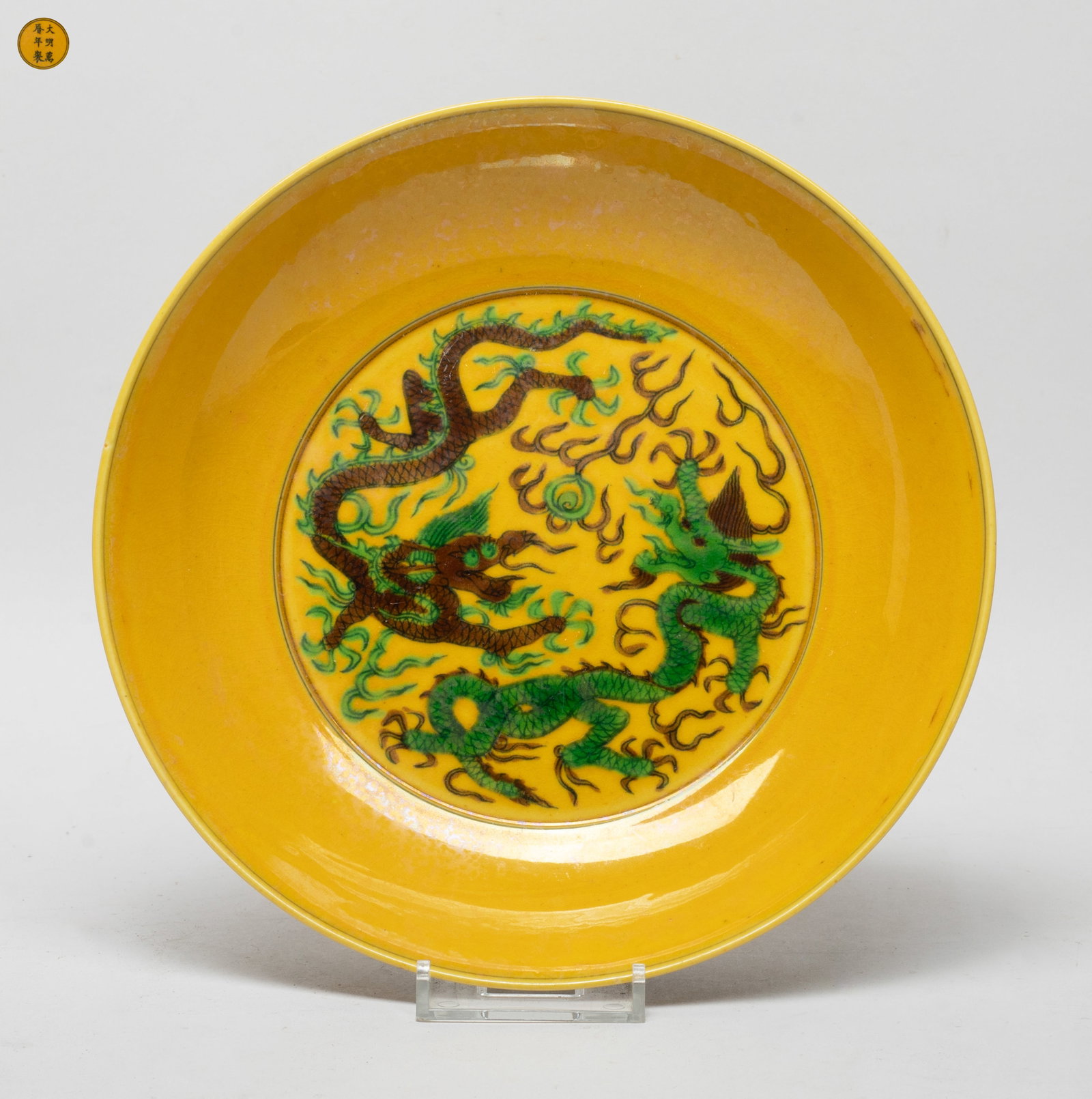 Collectible Chinese Export Porcelain Deep Plate: The plate interior centre painted with two dragons chasing a flaming pearl in brown and green colors, the exterior with leafy floral scrolls, all against yellow glazed body, the bottom marked with six