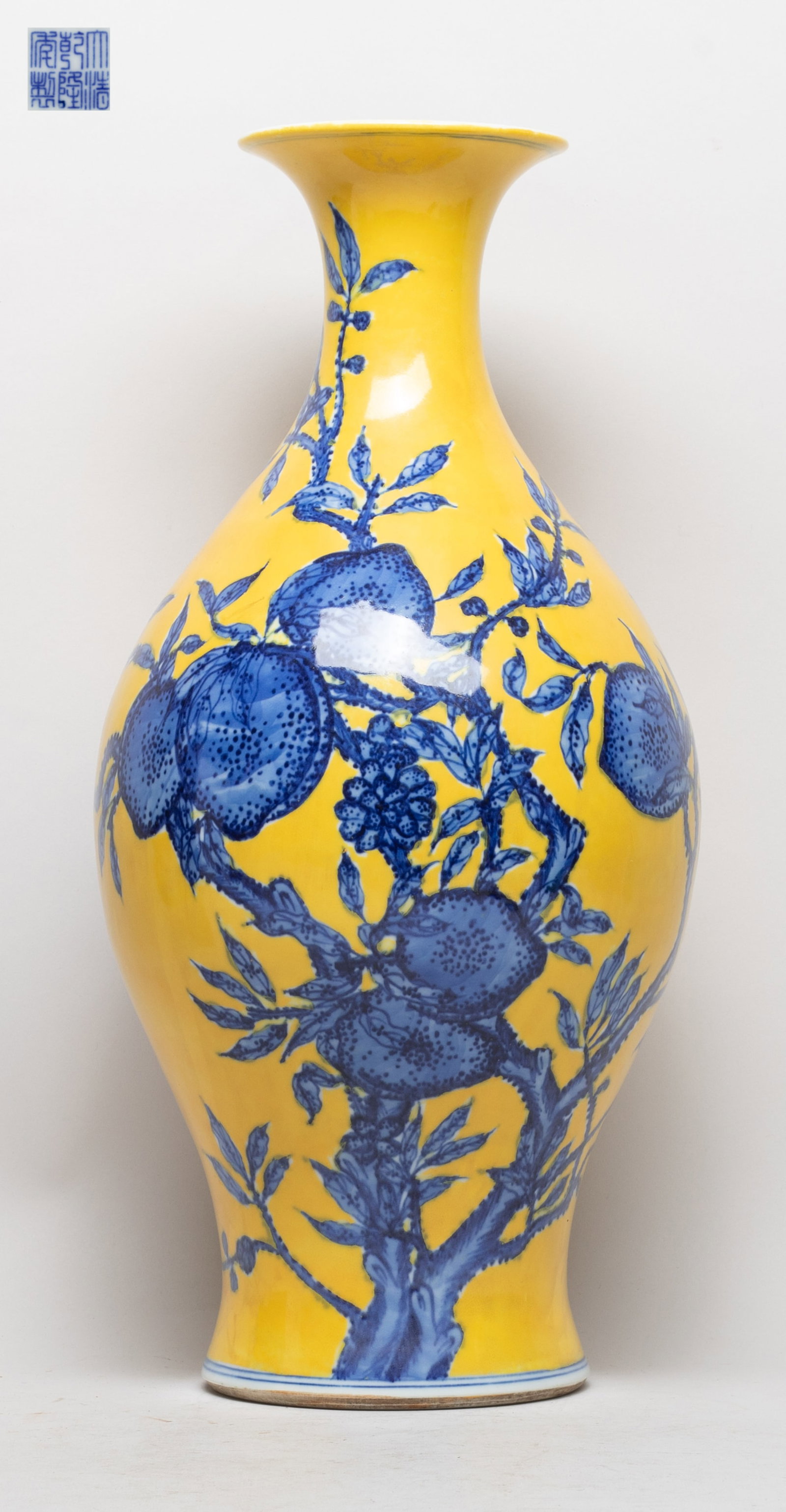 Tall Chinese Export Porcelain Vase: The ovoid body rising from a splayed foot to a waisted neck and a flared rim, the exterior painted with fruiting leafy peach tree branches, against yellow glazed background, the bottom with a six-char