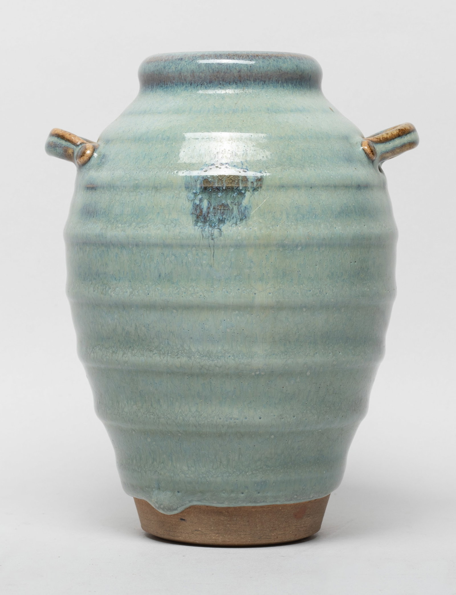Estate Chinese Jun ware Porcelain Cabinet Vase: Of tall ovoid form with two raised handles, carved with parallel borders, the inside and out covered with bubbled milky-blue glaze, the thick glaze stopping above the unglazed foot. Approx. 6*4.7*4.2 