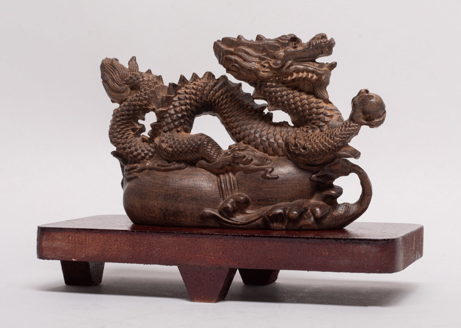 Chinese Export Wood Table Sculpture: Skillfully carved as a sinuous dragon over a double gourd, with one paw carrying a ball, with stand. Approx. 120 gram, 4.7*2.9*1.4 inch (w/o stand).