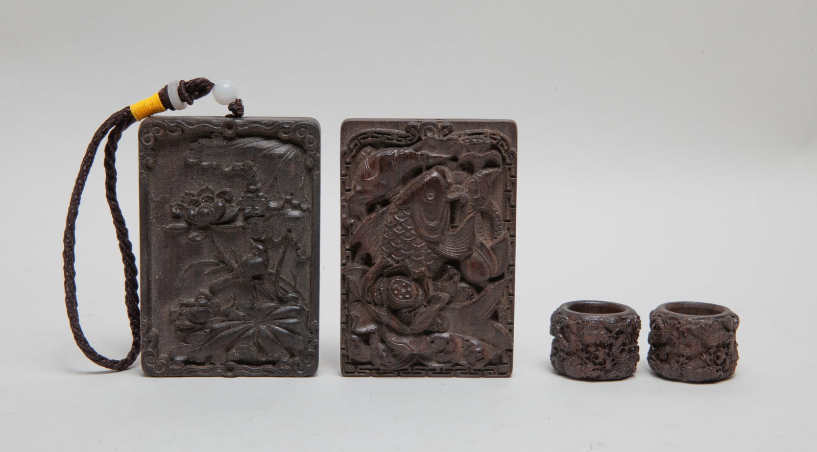 Estate Chinese Export Agarwood Plates, Rings: Including two agarwood thumb rings and two plaques. Approx. 232 gram (total wood weight), 3.9*2.7 inch (larger plaque size).