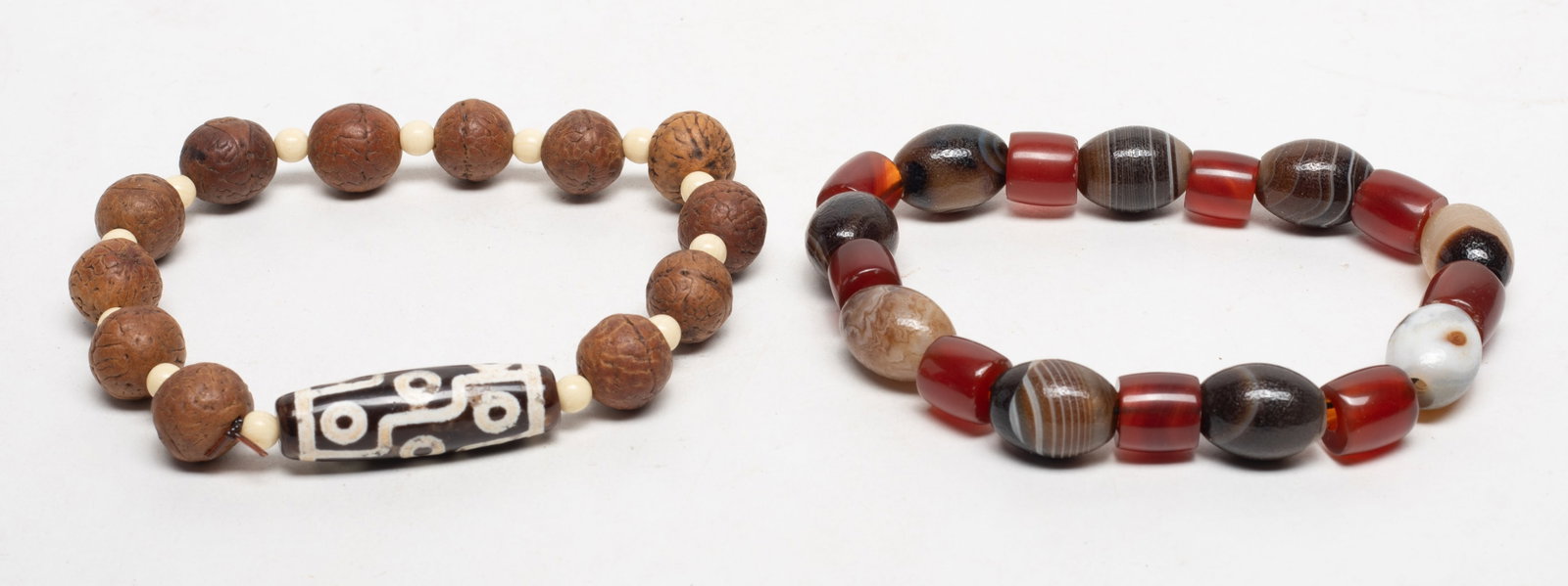 Chinese Export Agate Seed Prayer Beads: Two strings of Chinese export agate and seed carved prayer beads. Approx. 1.47 inch L (longest bead).