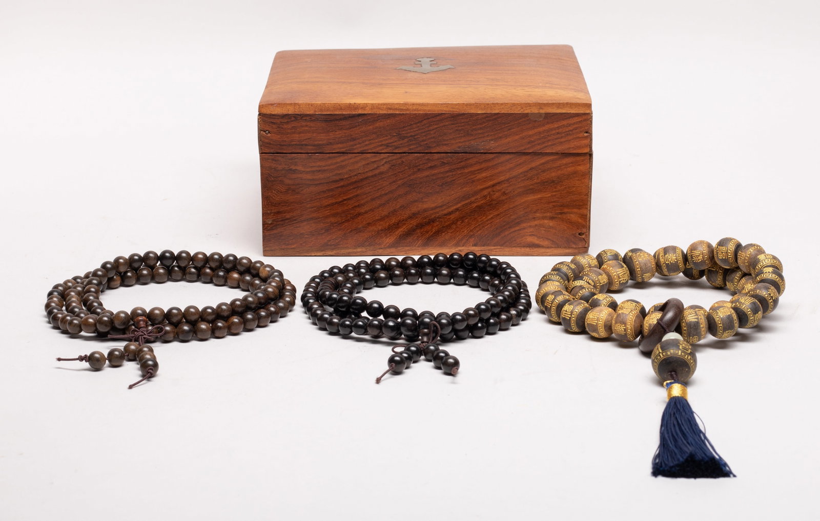 Chinese/ South Asian Agarwood Prayer Beads: Three long strings of Chinese / South Asian agarwood prayer beads, wherein one string of beads incised and gilded with stylized characters and decorated with tassel, with box. Approx. 0.75 inch D
