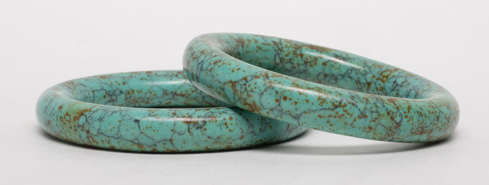Estate Two Chinese Stone Bangles: Two Chinese stone carved bangles. Approx. 3.3 inch outer diameter, 2.35 inch inner diameter (each).