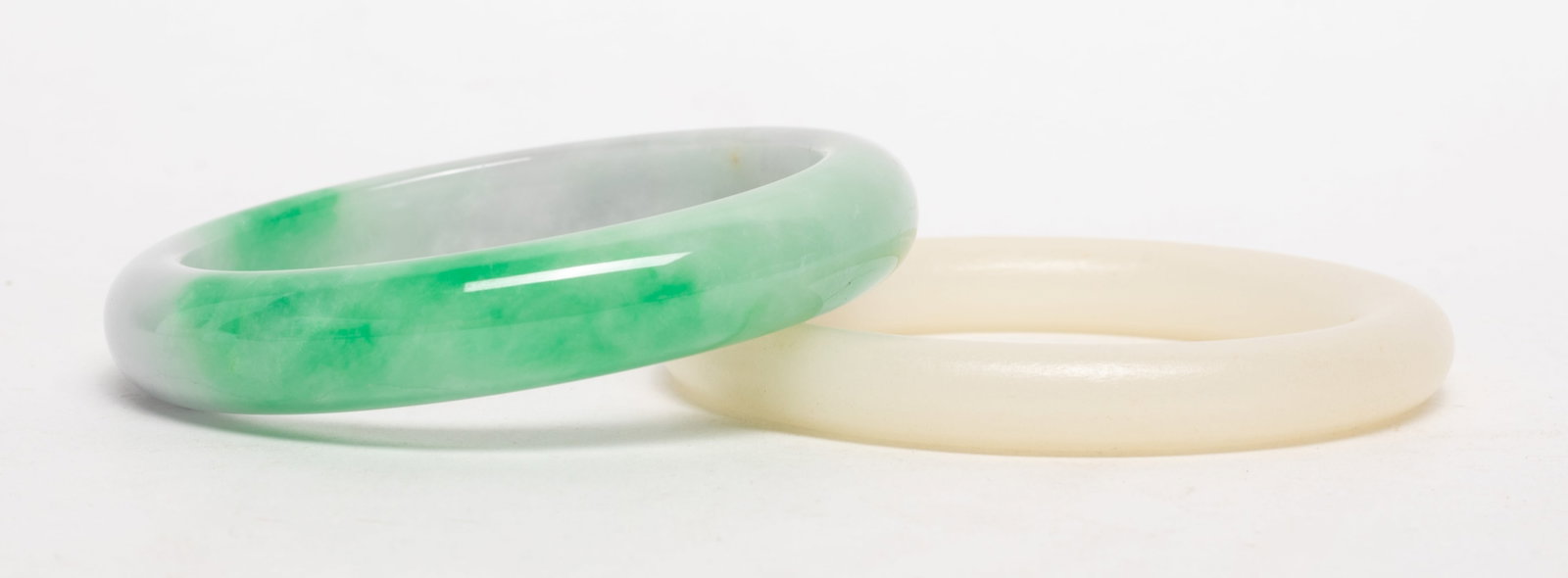 Two Chinese Colored Stone Bangles: Two Chinese colored stone carved bangles. Approx. 3.28 inch outer diameter, 2.55 inch inner diameter (larger bangle).