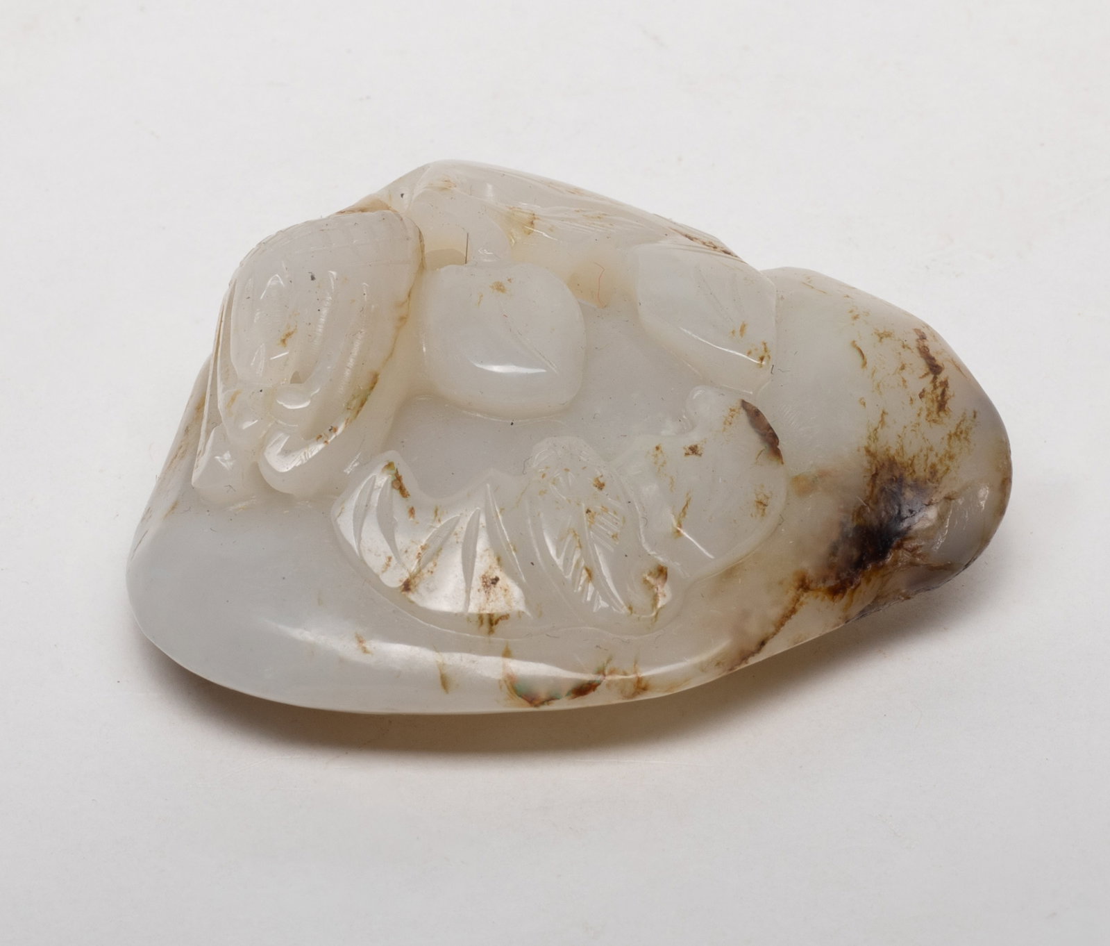 Chinese Export Pebble Jade Pendant: Chinese white and russet jade pendant carved lingzhi, peach, buddha hand citron and bat. Approx. 2.4*2.07*0.83 inch.