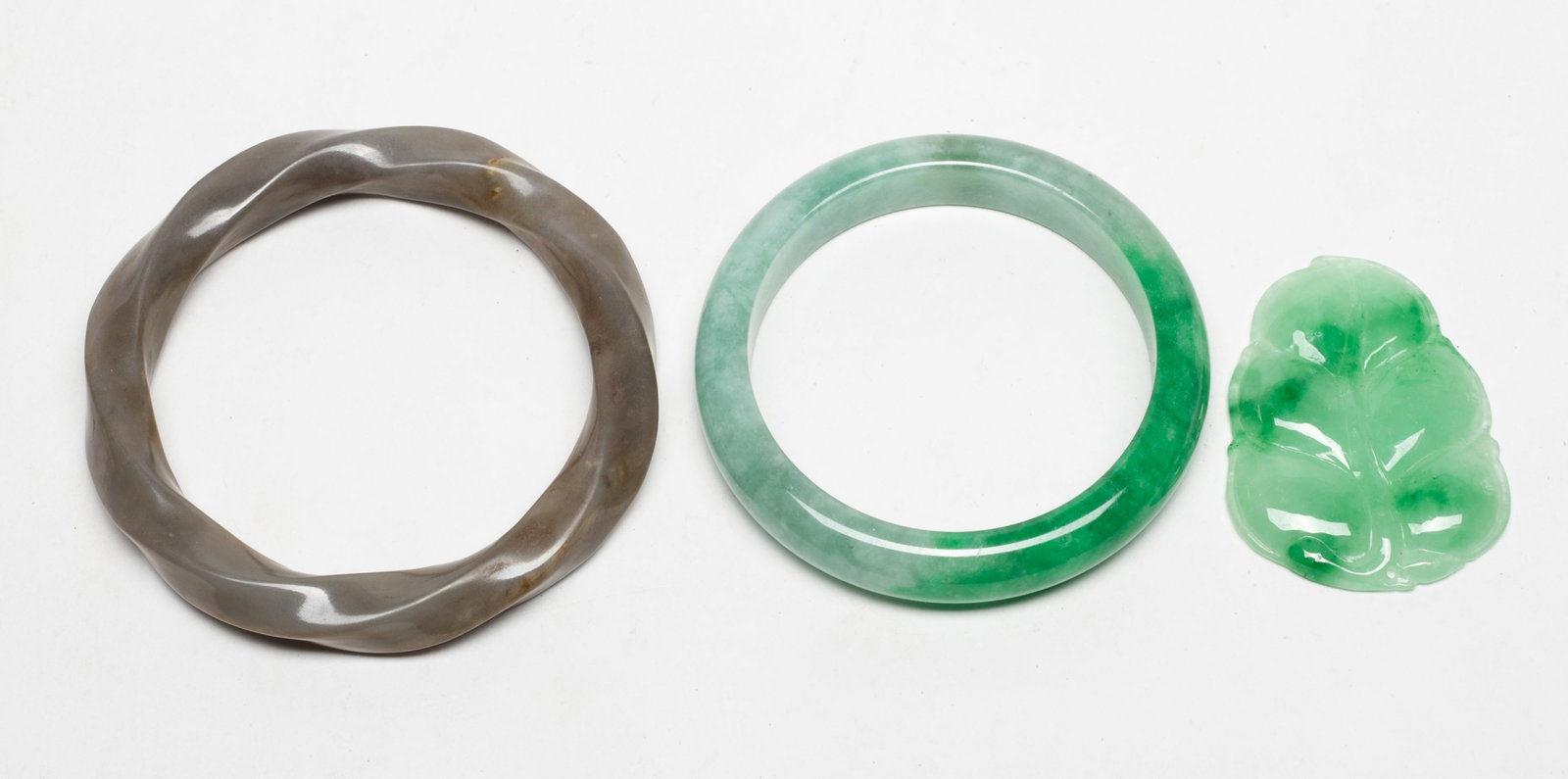 Estate Chinese Jade Bangles, Pendant: Including two bangles and a leaf form pendant. Approx. 3.2 inch outer diameter, 2.35 inch inner diameter (larger bangle).