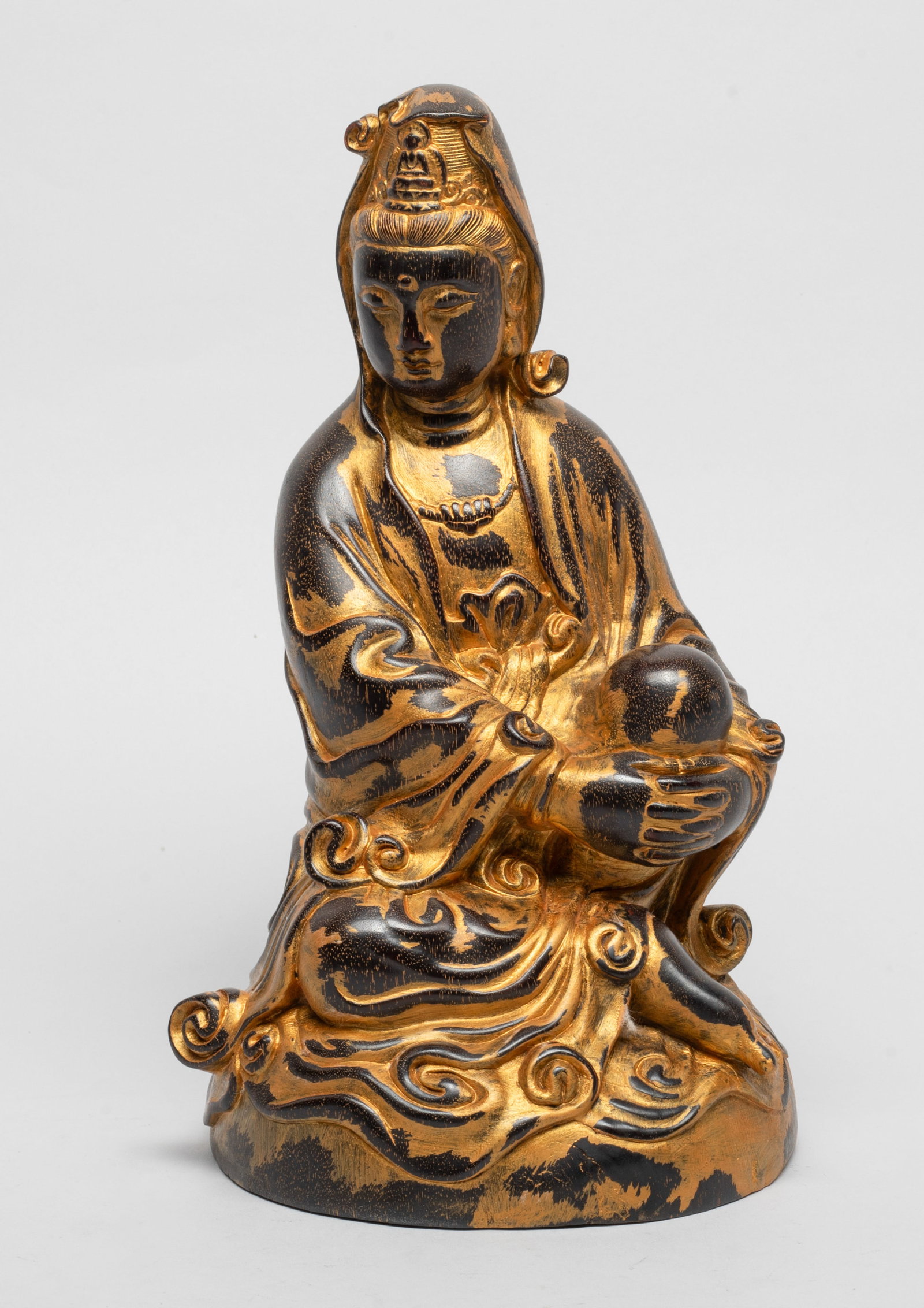 Chinese Painted Wood Sculpture of Buddha: Carved in seated pose, the hands crossed encircling left bent leg, the right leg resting in front of body, wearing a long flowing robe, the meditative face turned slightly to right. Approx. 9.5*5.5*5.