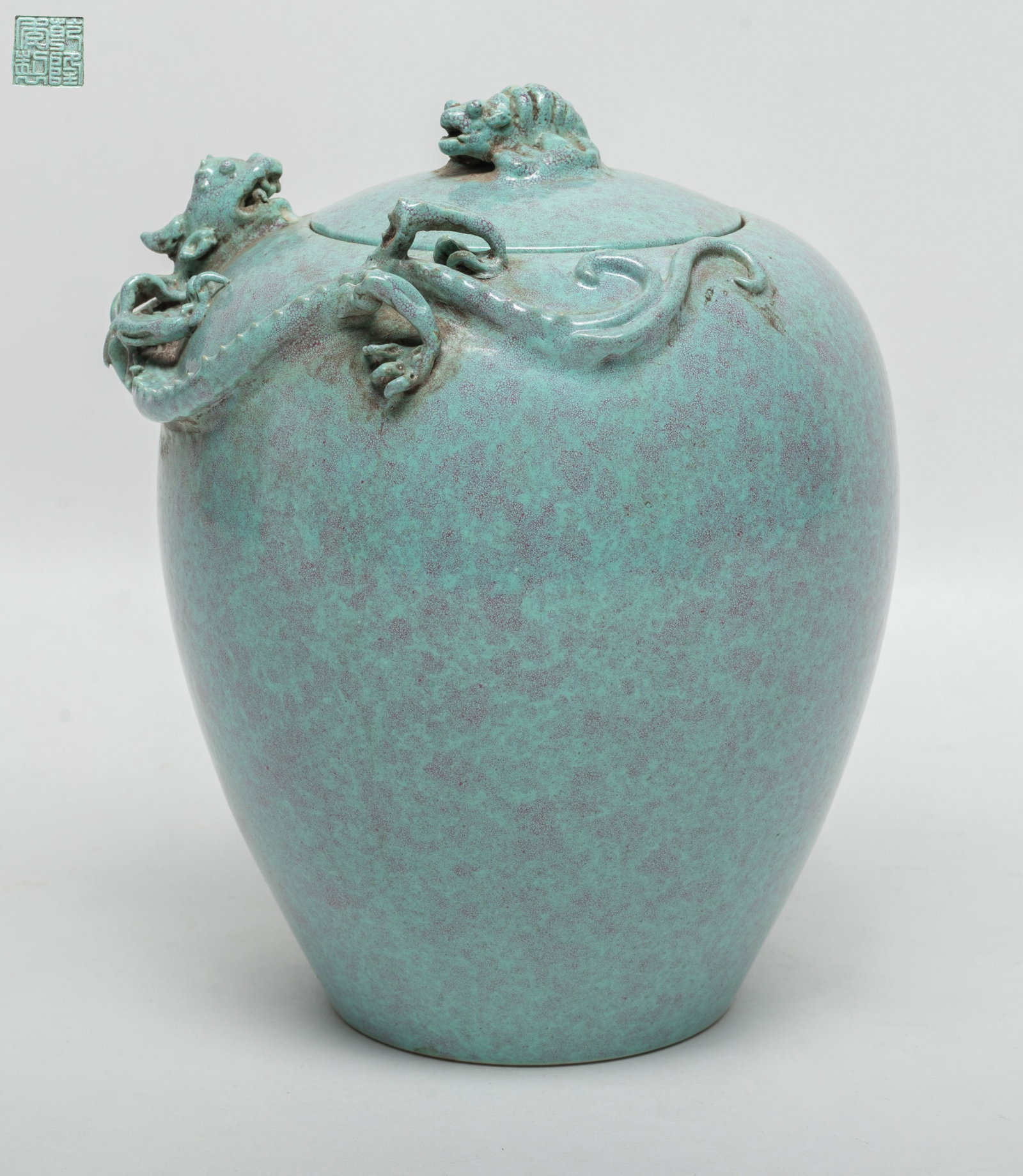 Chinese Flambe Glazed Porcelain Covered Jar: Chinese flambe glazed porcelain covered jar, carved in relief with dragon, incised four characters to underside. Approx. 6.7*5.7*5.2 inch.