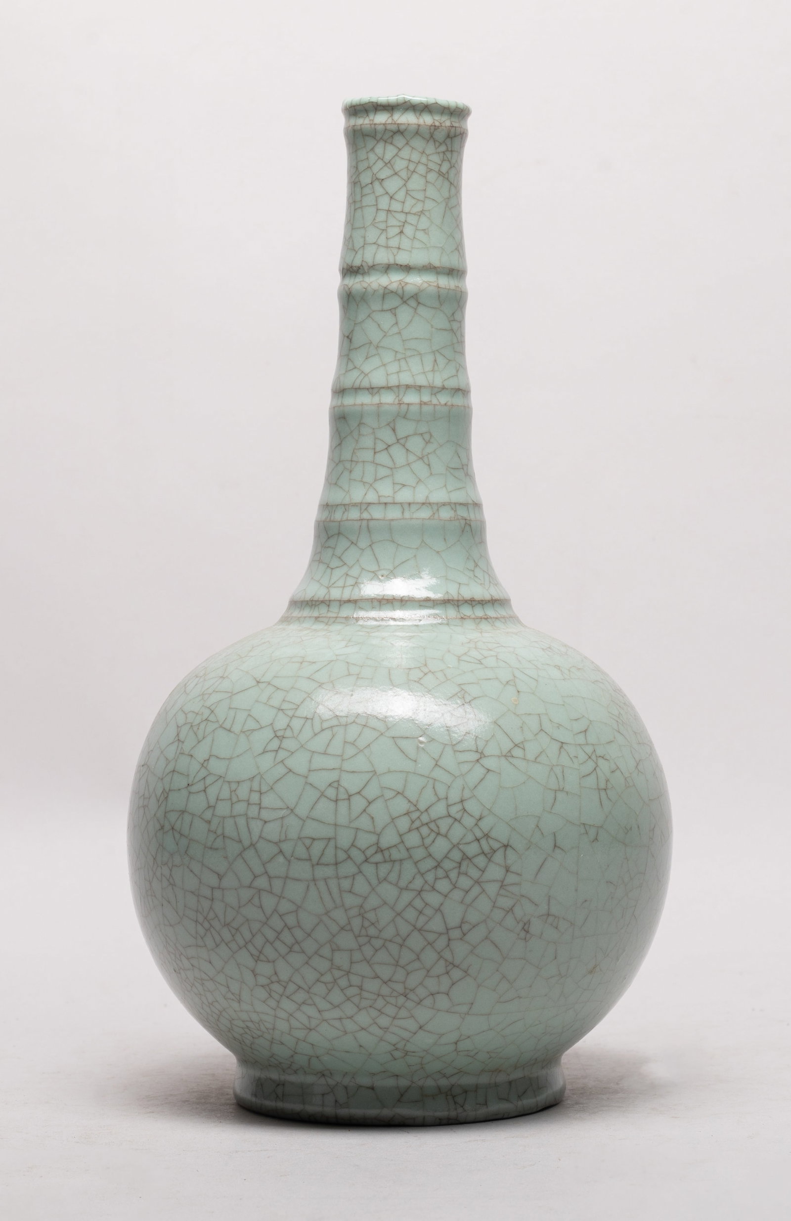 Chinese Export Crackle Glazed Porcelain Vase: The globular body rising from a short foot to a tall slender neck, overall covered in bluish celadon glaze suffused with a matrix of crackles. Approx. 10.6*5.7 inch.