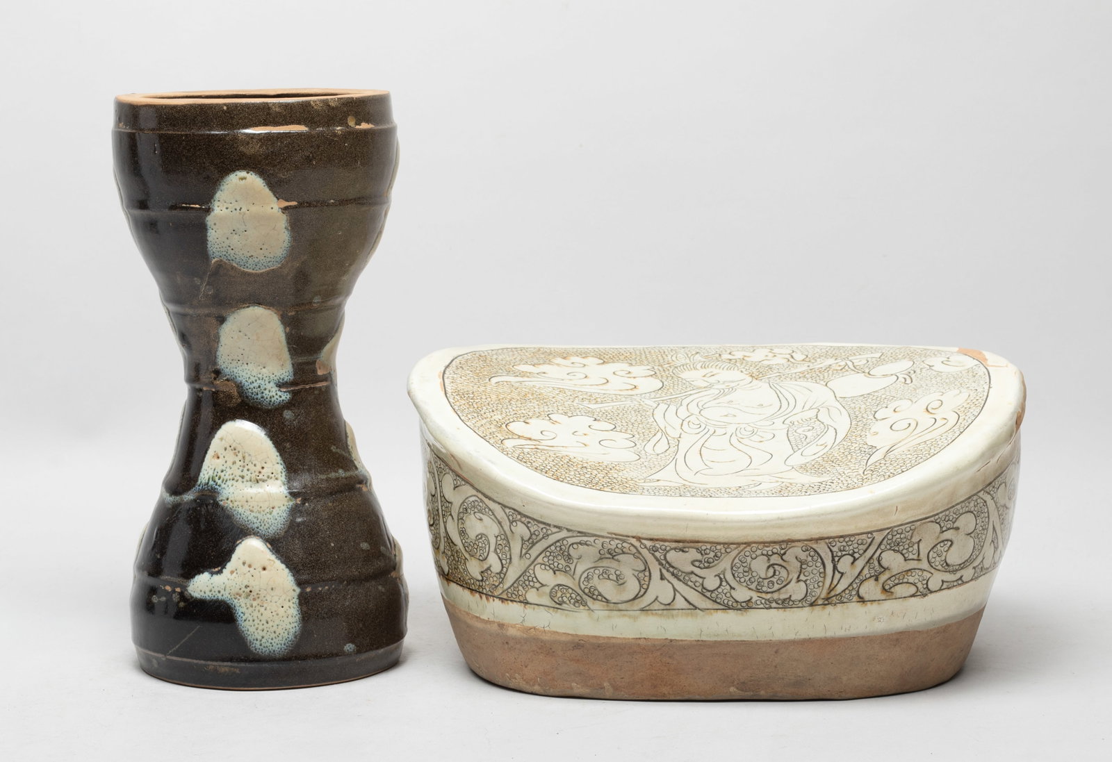 Large Chinese Cizhou Porcelain Pillow, Vase: Including a waisted form vase with no bottom, the exterior covered in dark brown glaze with creamy splashes, and a pillow incised with a figure among clouds on the top and flower scrolls on the sides.
