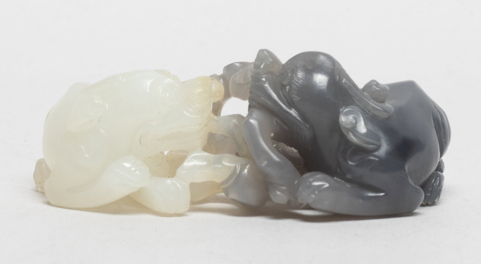 Unusual Chinese Jade Carved Pendant: Chinese jade pendant carved as two recumbent beasts grasping lingzhi branches. Approx. 2.4*1.5*0.88 inch.