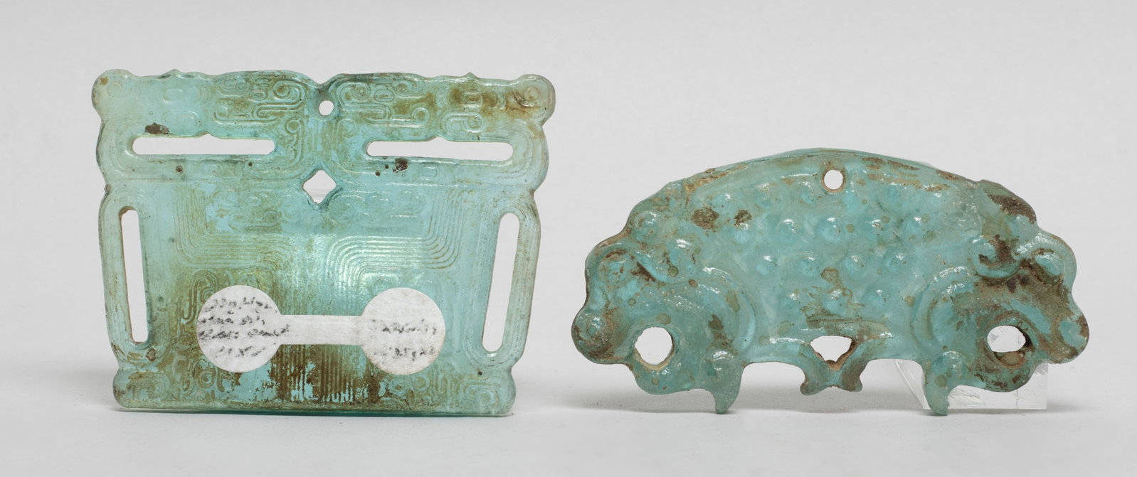 Two Chinese Early Type Glass Pendants: Two Chinese glass pendants, one carved with stylized dragon and the other caved mask. Approx. 2.6*1.9 inch.