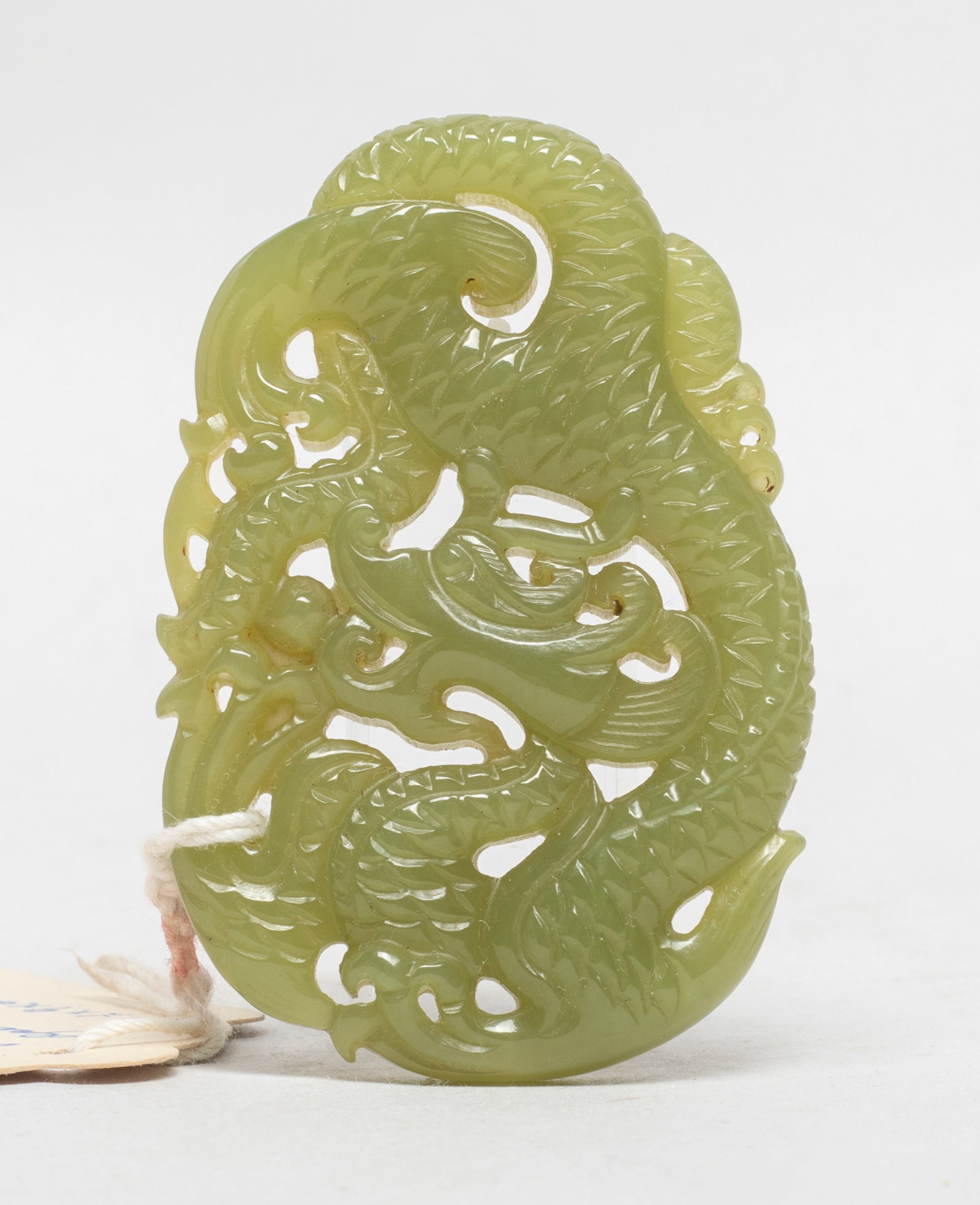 Chinese Export Yellow Jade Pendant: Chinese yellow green jade pendant carved of sinuous dragon form. Approx. 2.5*1.7 inch.