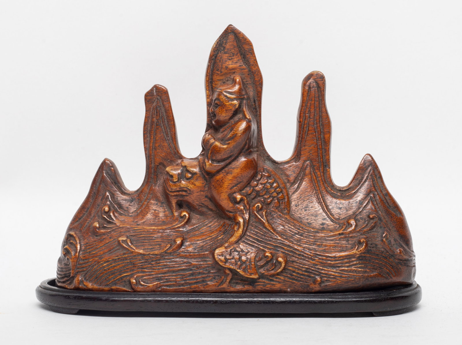 Chinese Agarwood Brush Stand: Mountain shaped agarwood brush stand carved with figure riding on dragon, with stand. Approx. 6.5*4.6*2.5 inch (w/ stand).