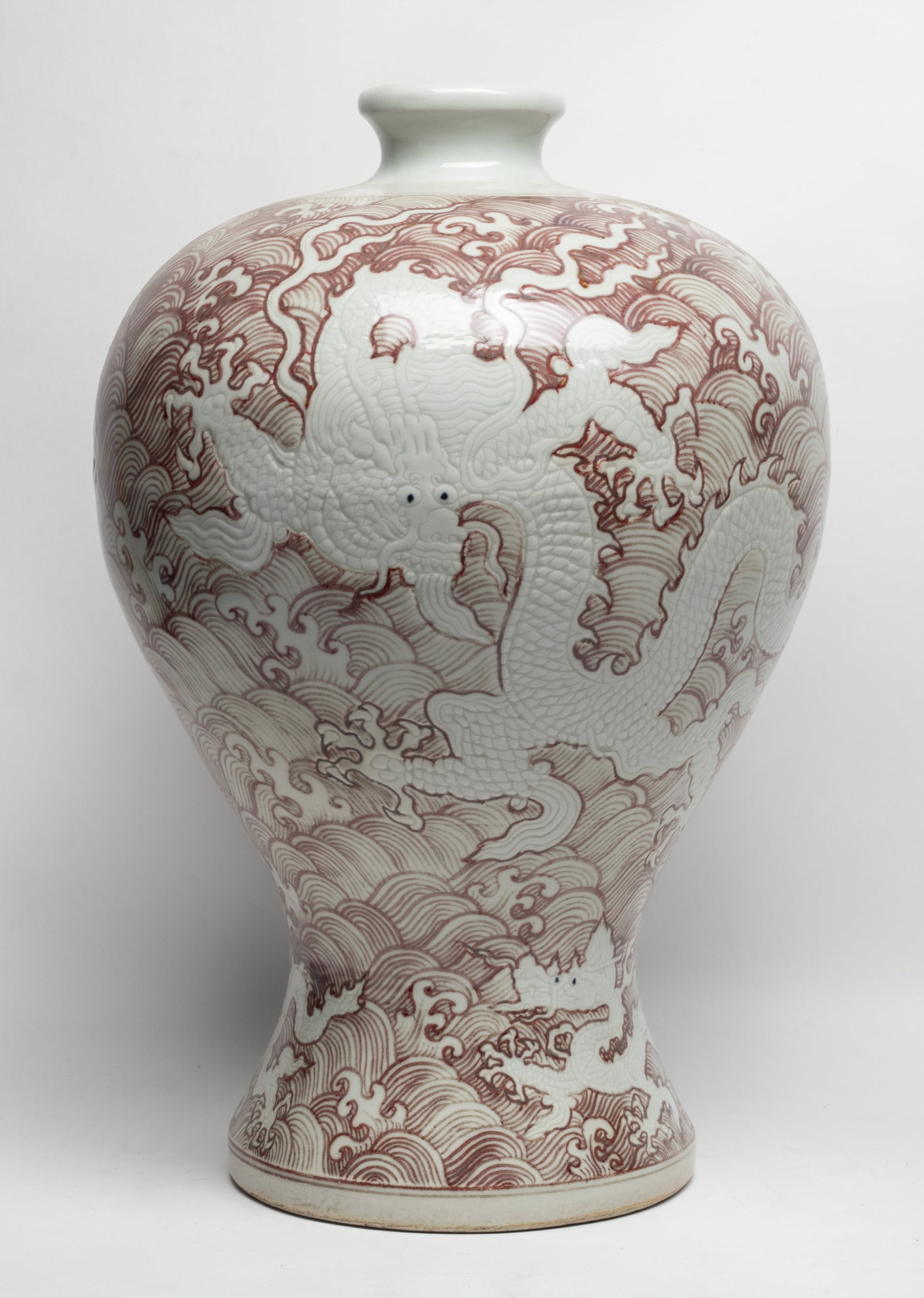 Tall Chinese Copper Red Glazed Porcelain Vase: Large Chinese porcelain vase, incised and painted in copper red with dragons over waves. Approx. 17*11.5 inch.