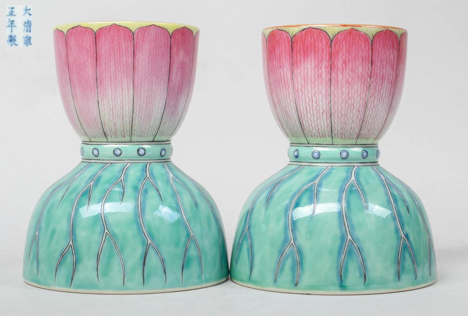 Two Chinese Export Porcelain Candlesticks: Each of waisted form, the upper body painted with lotus petals, the lower body with lotus leaf, the bottom marked with six characters enclosed in double circles. Approx. 4.4*3.7 inch (each).