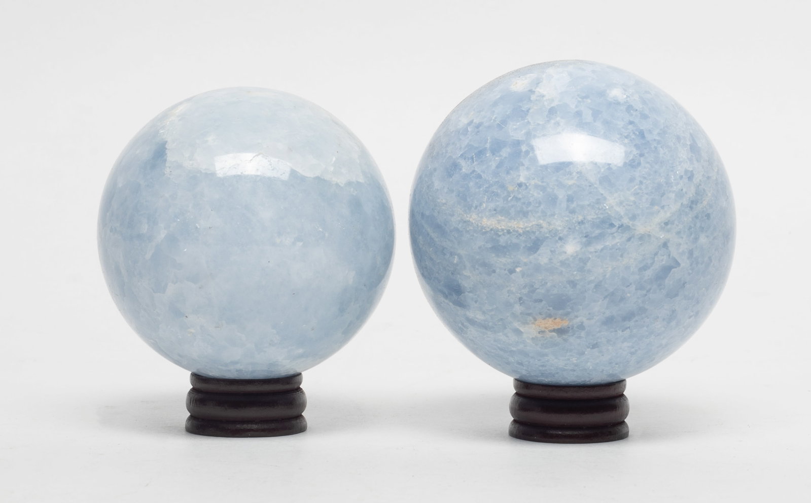 Two Vtg. Polished Stone Balls: Two polished blue calcite colored stone with stands. Approx. 2.95 inch D (larger ball size).