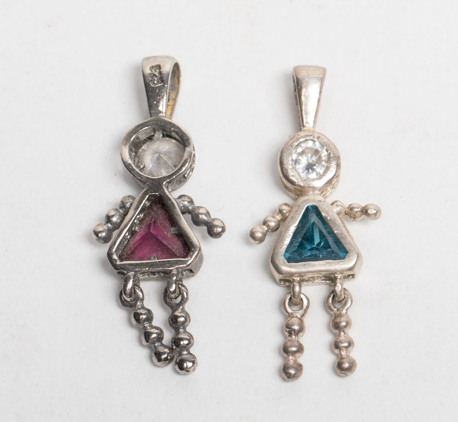 Two Sterling Silver Nature Stone Pendants: Two sterling silver figure form pendants inlaid nature stone. Approx. 3.98 gram (total weight), 1.2*0.5 inch (each).