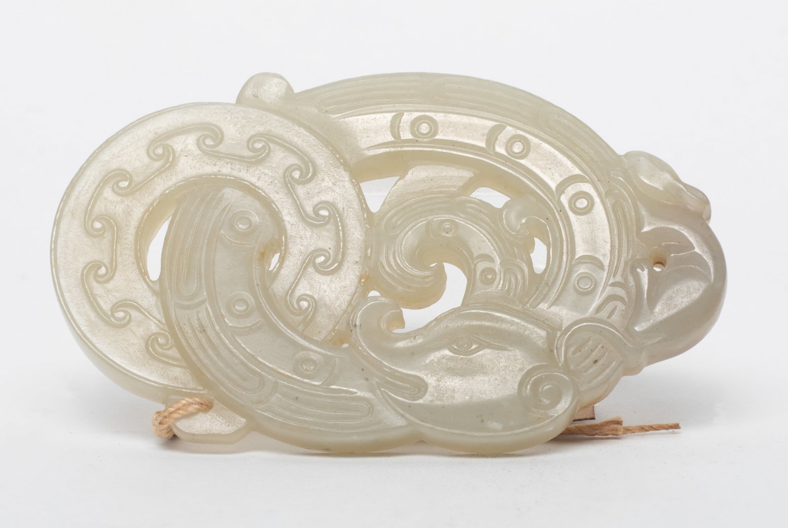 Estate Chinese Russet Jade Pendant: Carved as a stylized dragon with coiled body through a huan, a mouse on the top. Approx. 3.04*1.84 inch.