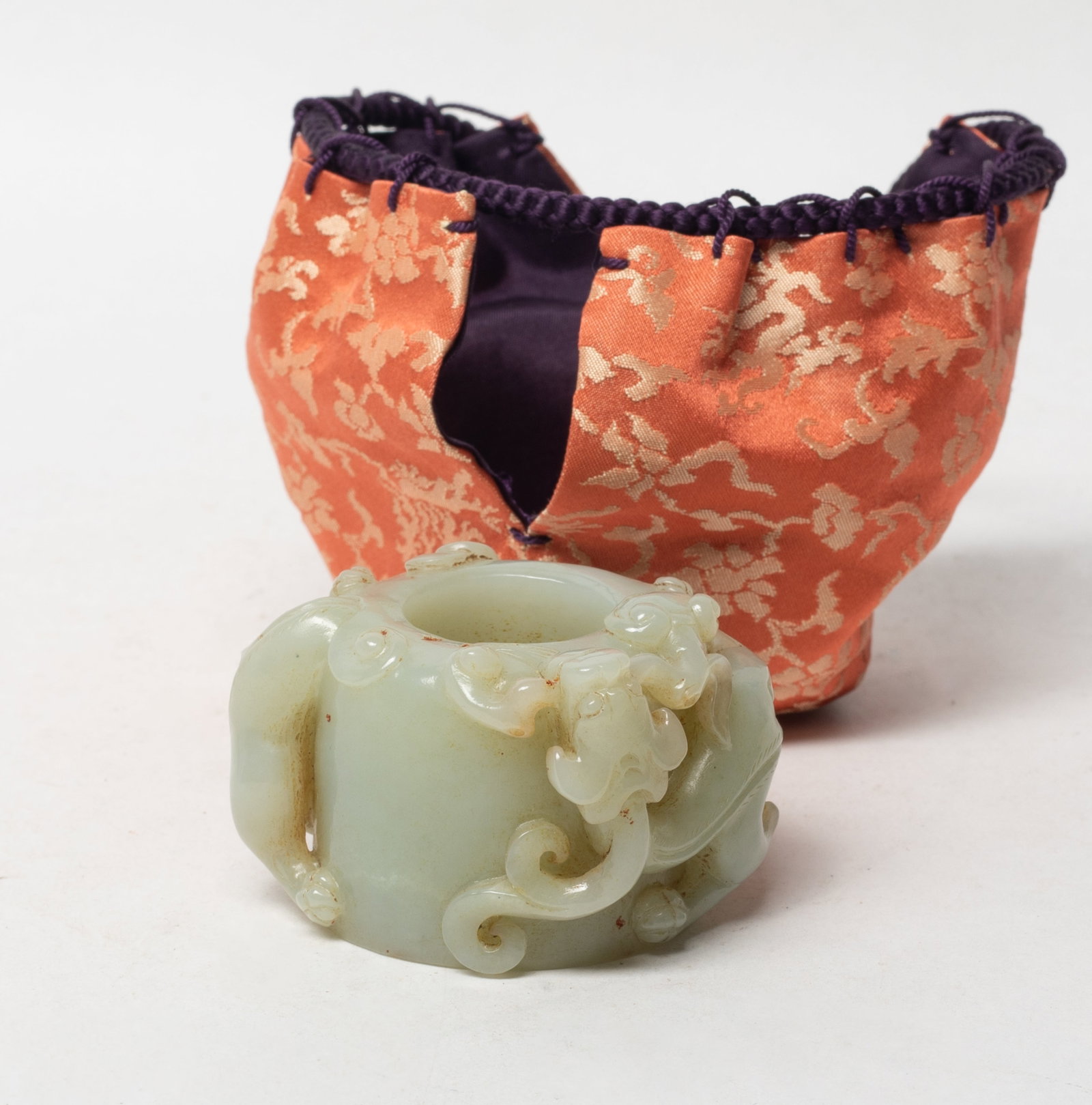 Large Chinese Jade Carved Dragon Thumb Ring: Large Chinese jade thumb ring carved in high relief with chi dragon grasping lingzhi, with bag. Approx. 1.43*2.07*1.7 inch.