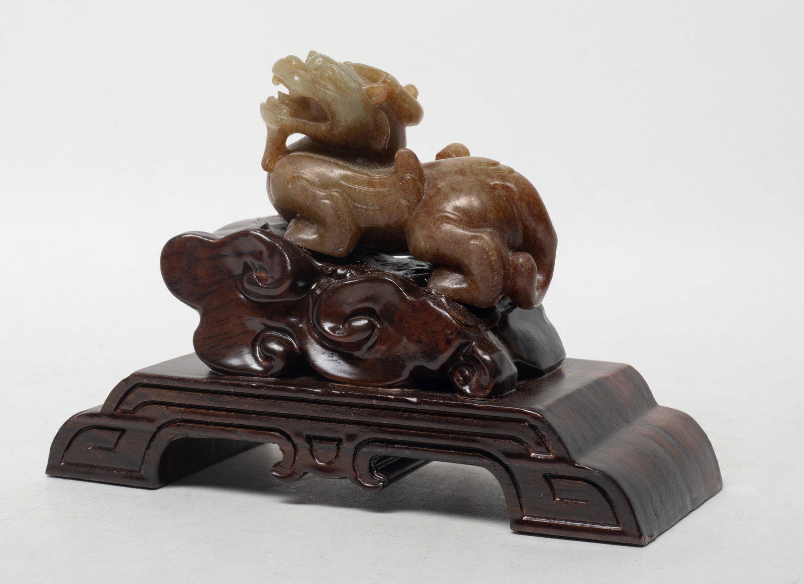 Rare Chinese Russet Jade Beast w/ Base: Chinese russet jade carved horned beast sculpture, with wood base. Approx. 2.97*1.82*1.52 inch (w/o stand). The Estate of the K. T. Lam. HK. 1998.