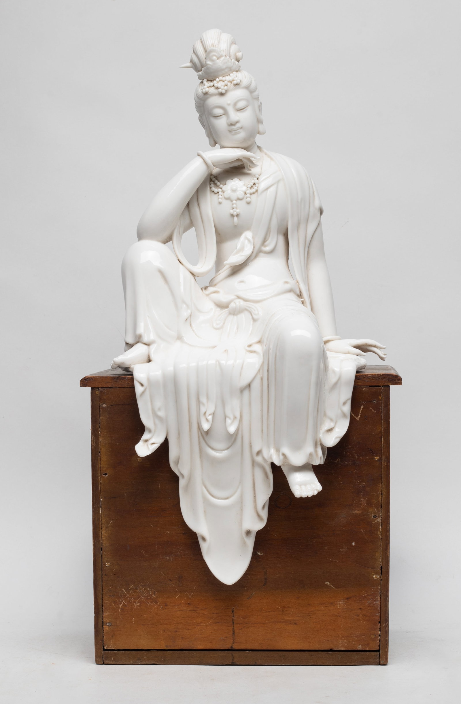 Unusual Chinese Blanc De Porcelain Kuanyin: Chinese cream white glazed sculpture of seated Buddha. The wood base for display only. Approx: 17.5*8.5 inch. The Estate ot the Lady. C. Chung One. Korean, 1992.