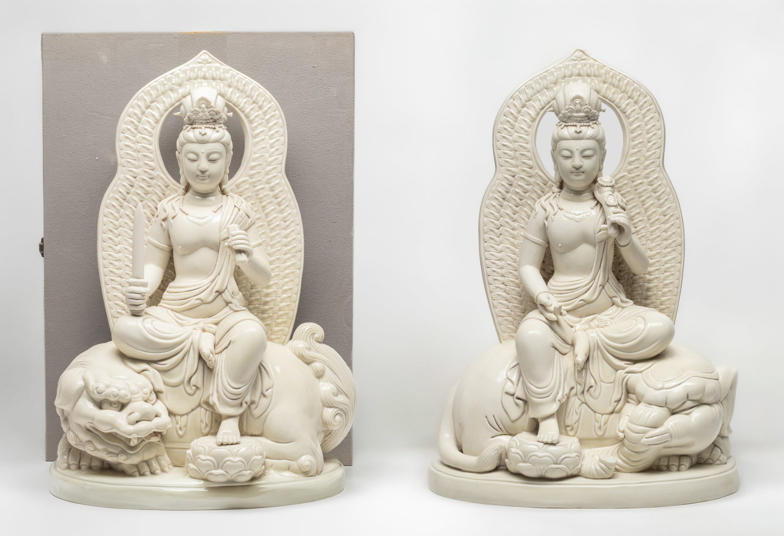 Two Large Chinese Blanc De Porcelain Buddha: Two large Chinese blanc de porcelain buddha, each is in sitting position upon the beast, with box.