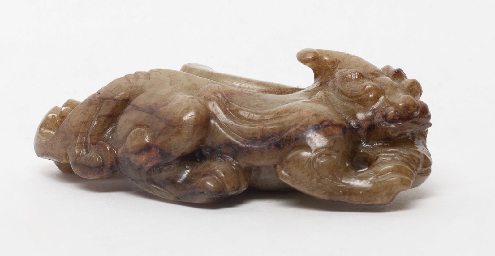 Chinese Russet Jade Beast Sculpture: Chinese russet jade sculpture carved as recumbent horned beast. Approx. 3.55*1.68*1.12 inch.
